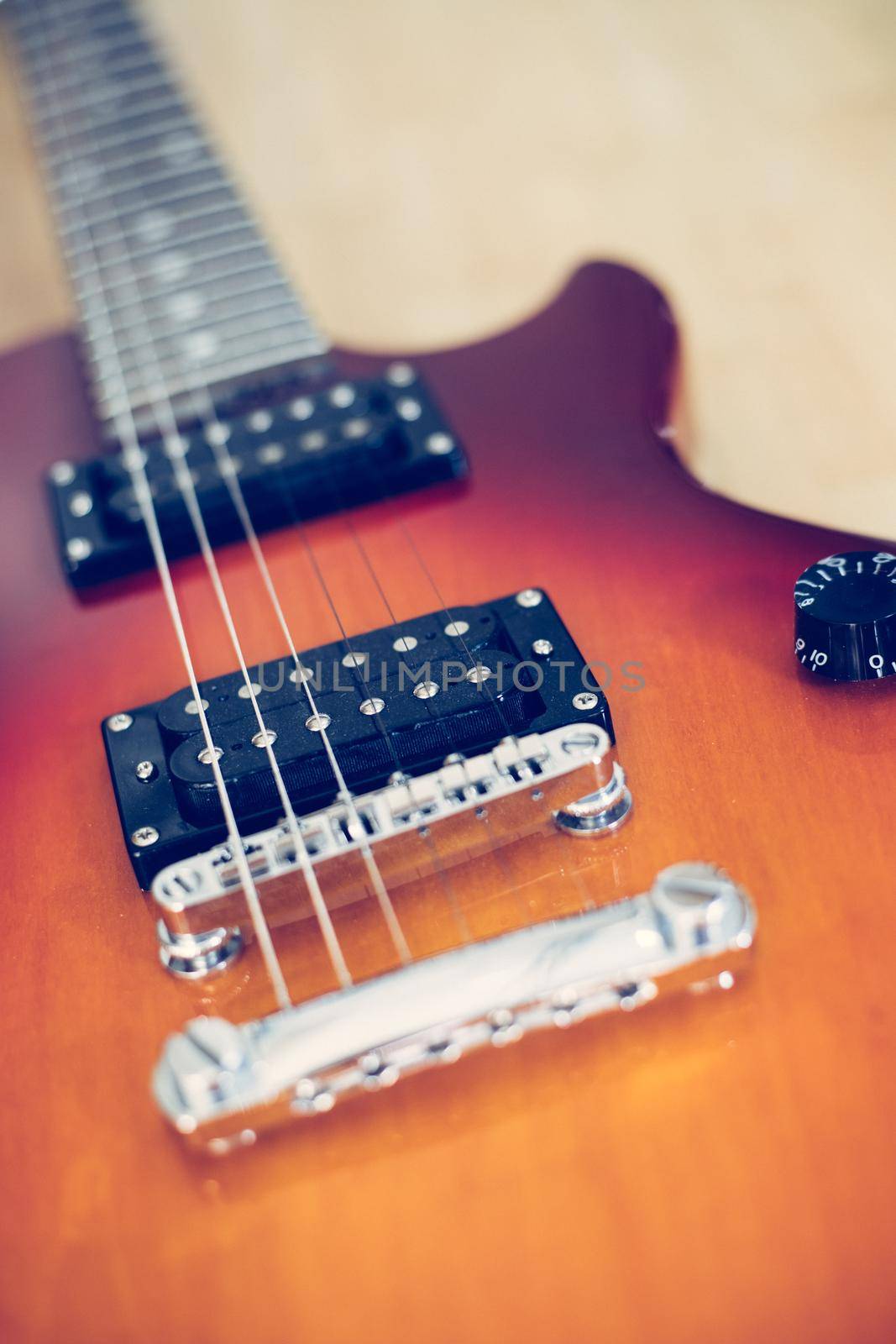 Electronic guitar in sunburst optic lying on the wooden floor