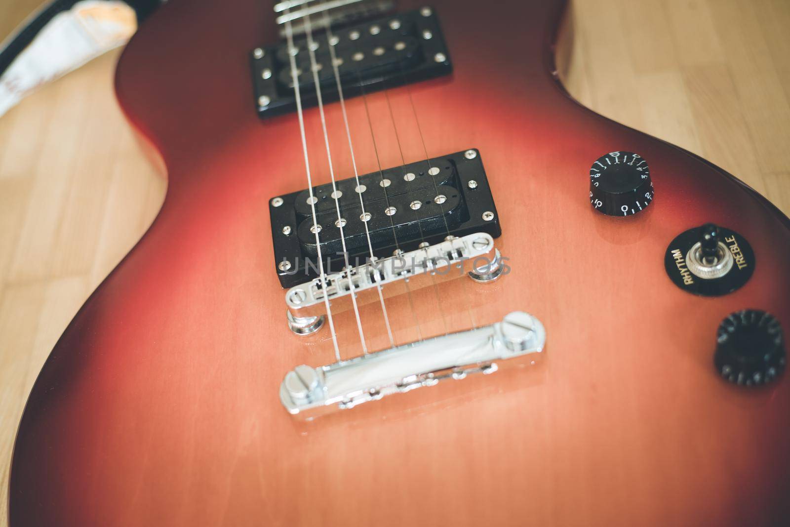 Electronic guitar in sunburst optic lying on the wooden floor