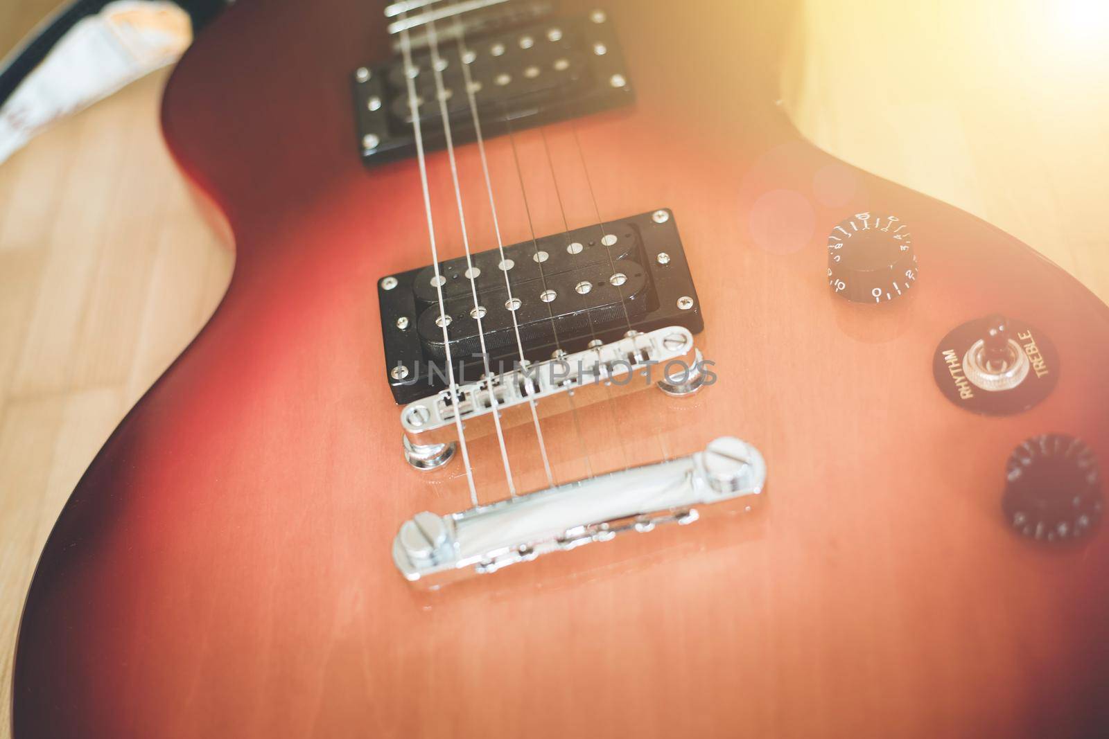 Electronic guitar in sunburst optic lying on the wooden floor