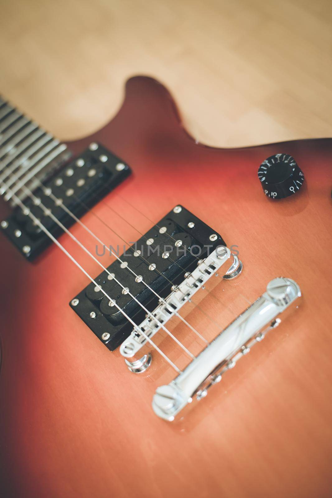 Electronic guitar in sunburst optic lying on the wooden floor