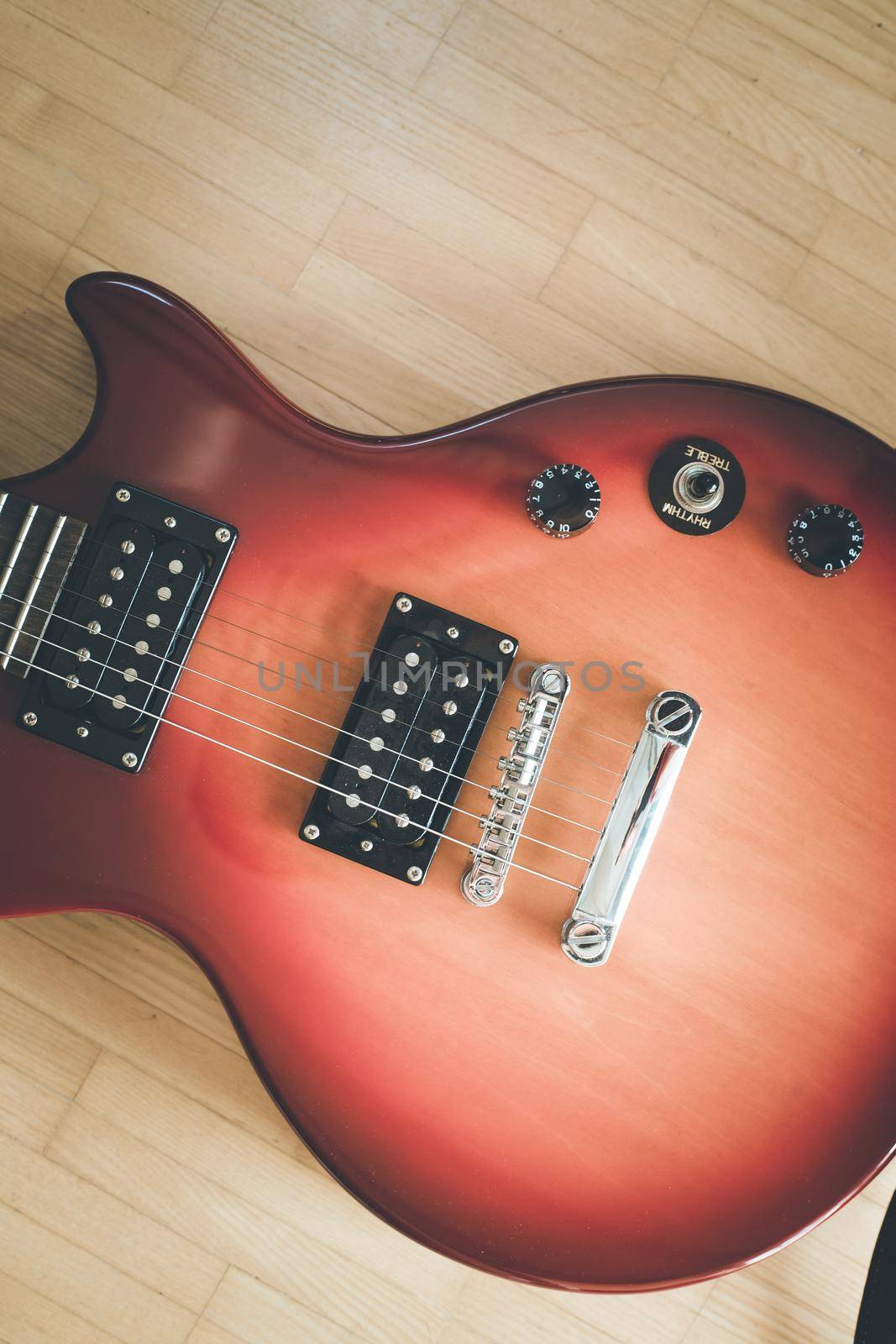 Electronic guitar in sunburst optic lying on the wooden floor