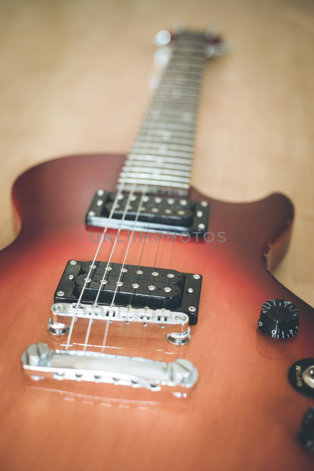 Electronic guitar in sunburst optic lying on the wooden floor