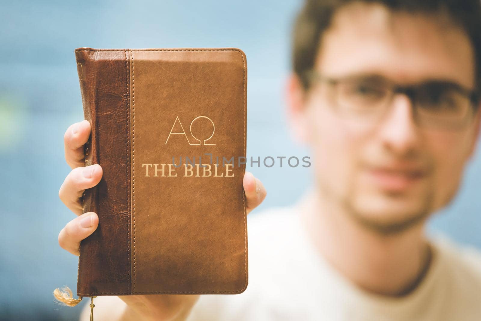 Young preacher is holding the holy bible, praying