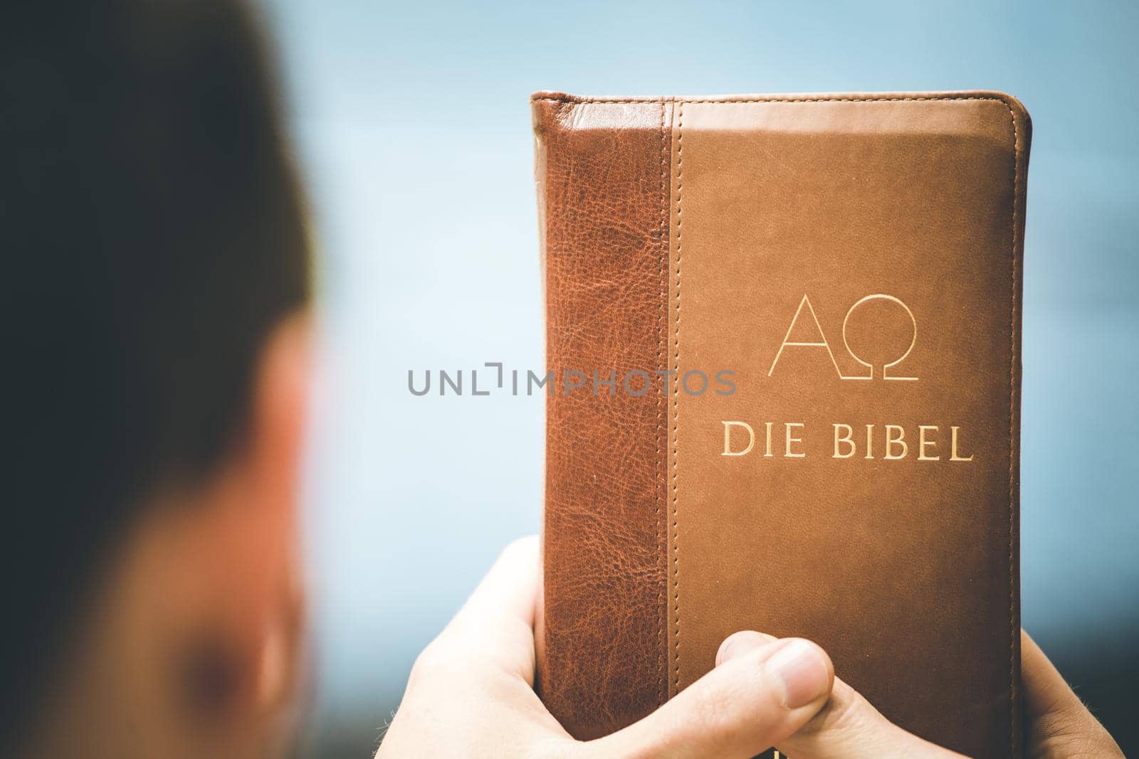 Young preacher is holding the holy bible, praying