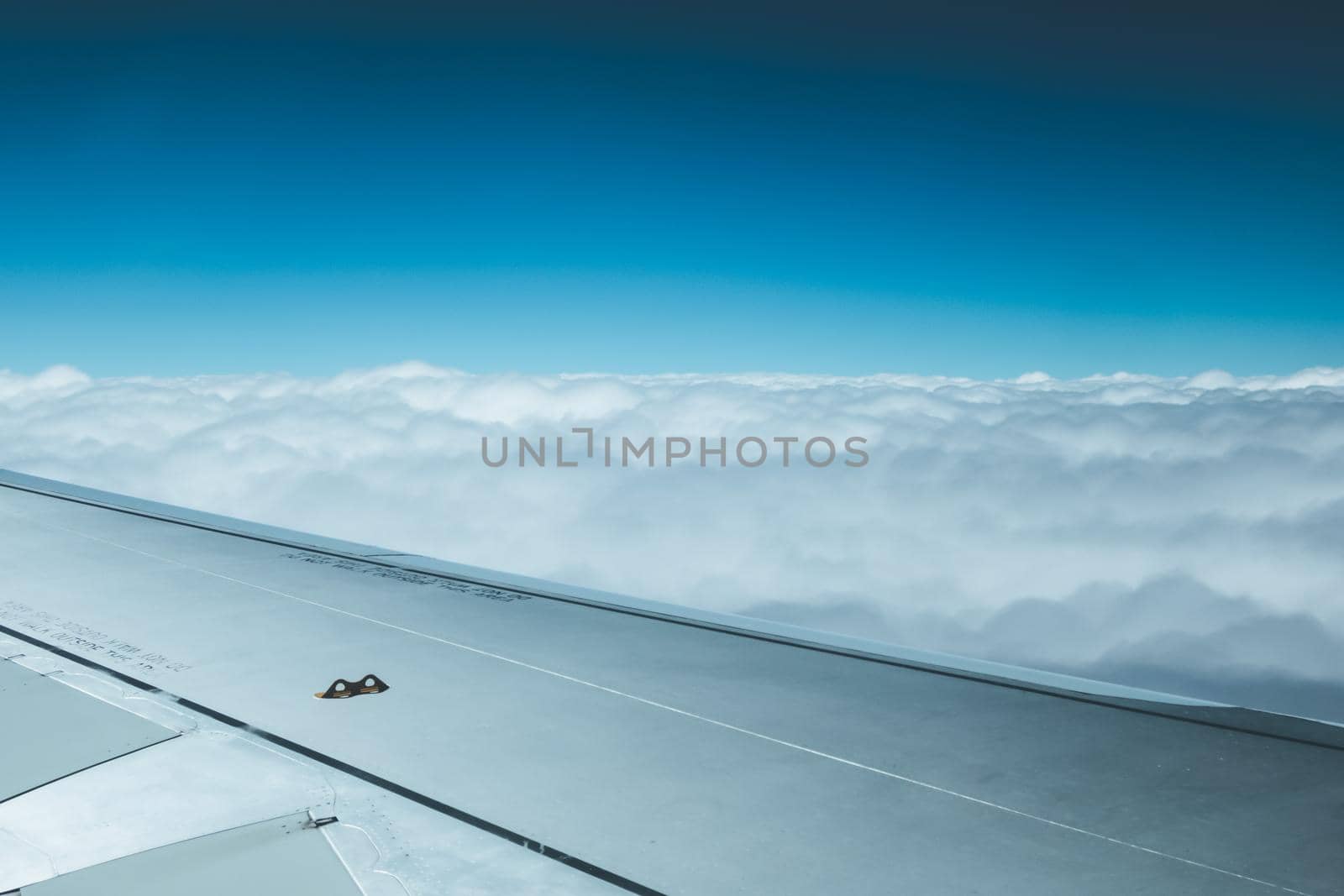 View of a grey airplane wing through the aircraft window. Global warming.