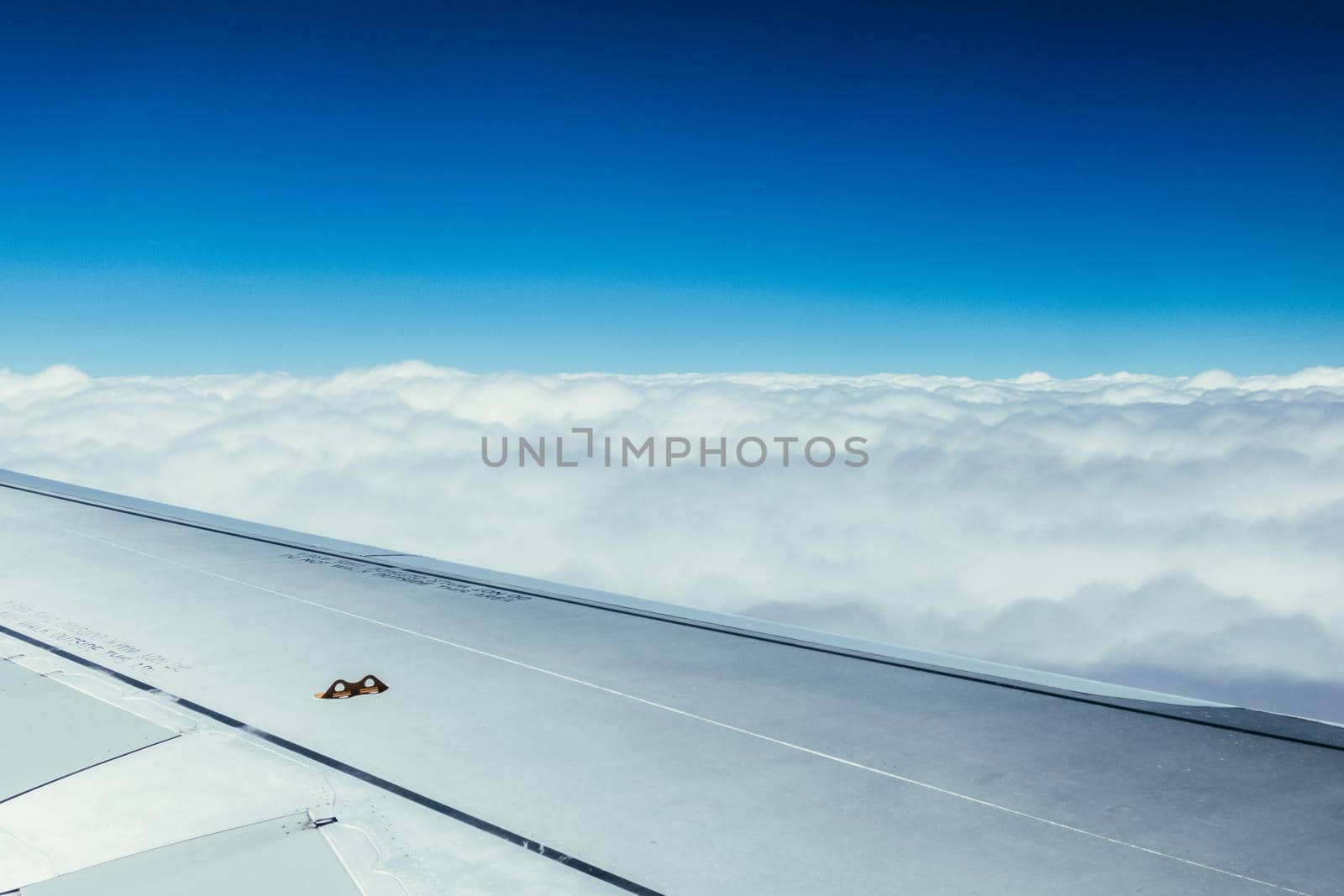 View of a grey airplane wing through the aircraft window. Global warming.