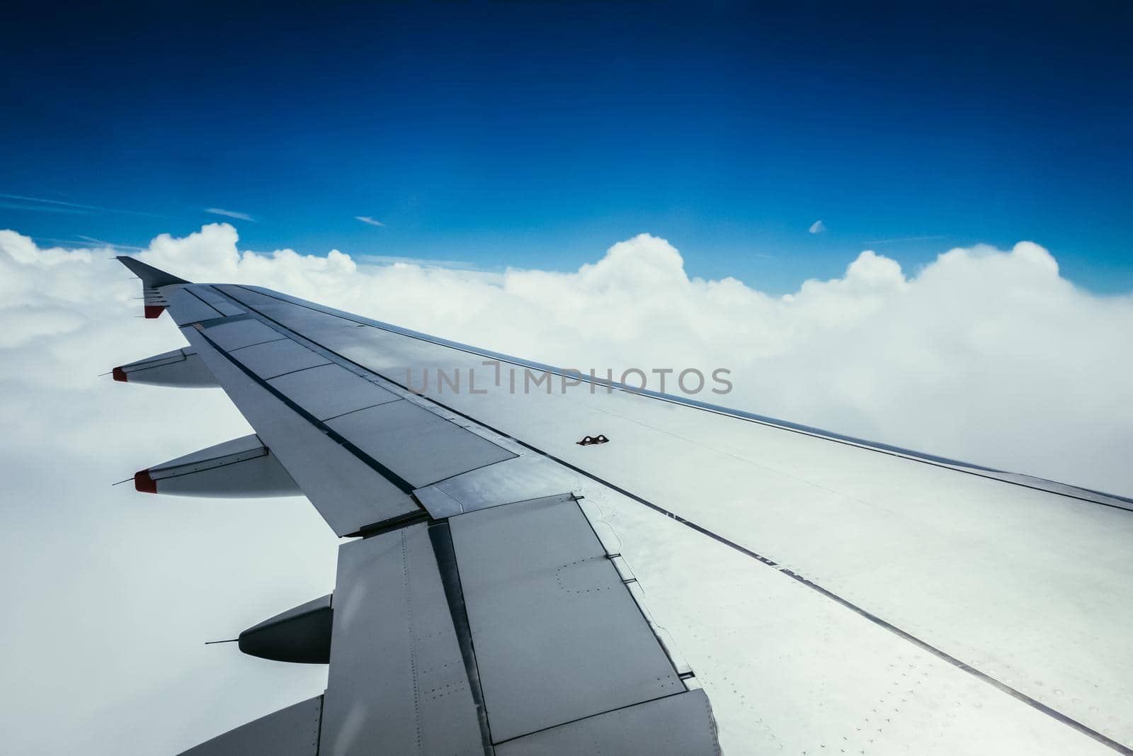 View of a grey airplane wing through the aircraft window. Global warming.