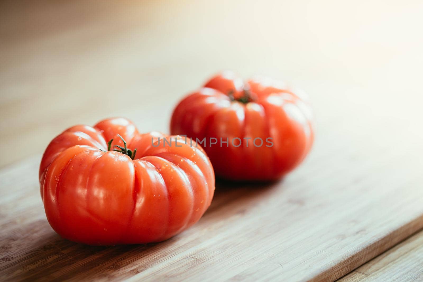 Oxheart tomatoes. Tomatoes on a bamboo wood plate. by Daxenbichler