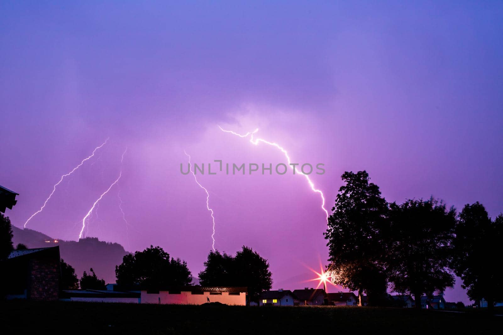 Thunderstorm in the night: Lightning on the colored sky. Global warming. by Daxenbichler