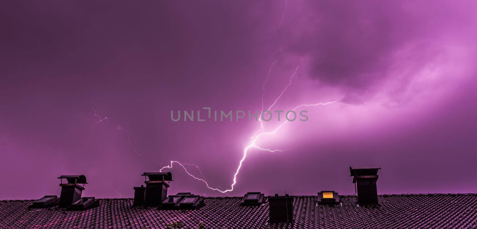 Thunderstorm in the night: Lightning over a roof of a building by Daxenbichler