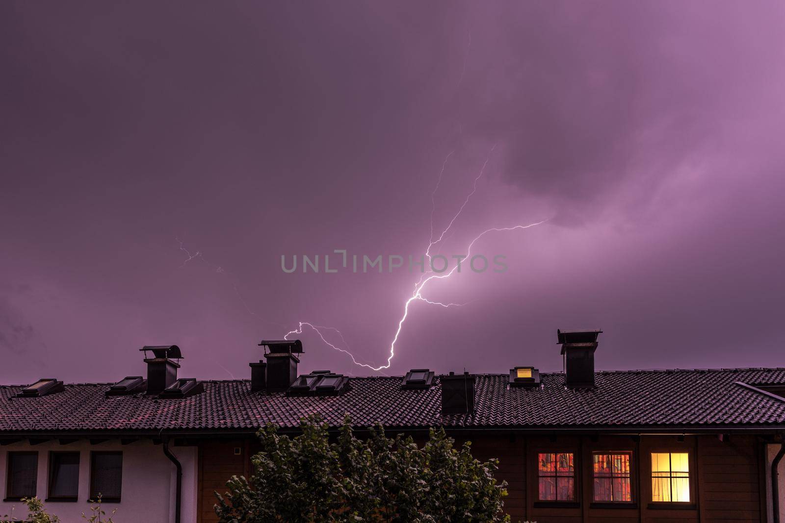 Lightning on the colored sky, roof of a building