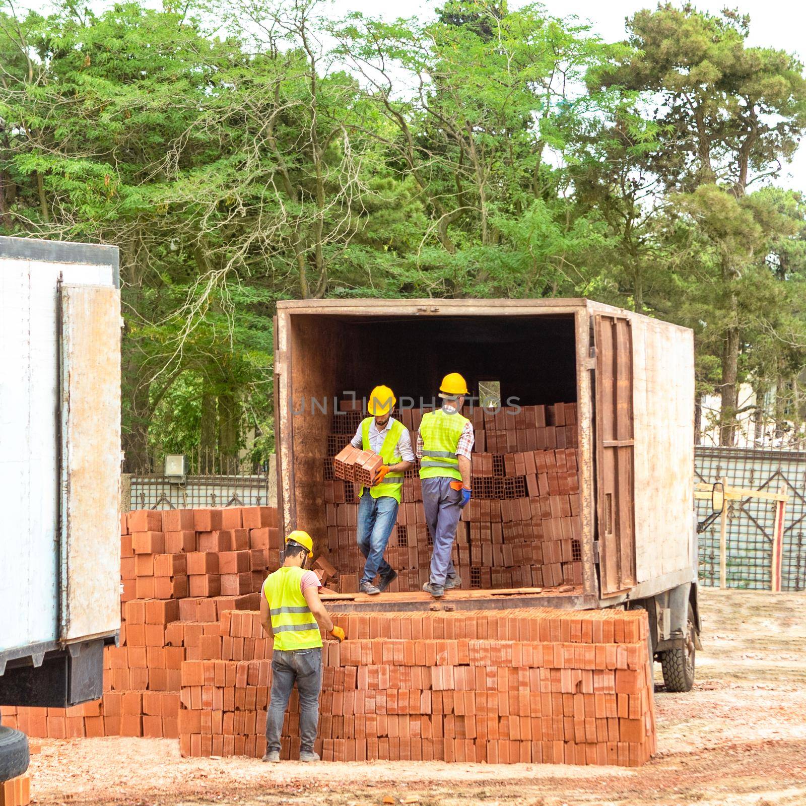 Construction workers unloading bricks