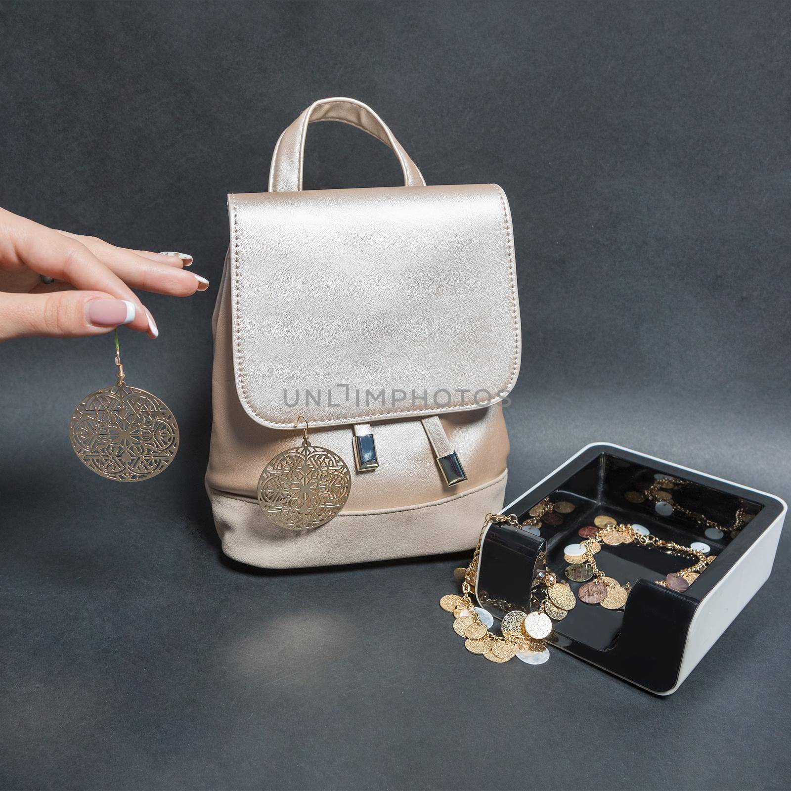 Holding a jewelry earrings with a woman bag isolated
