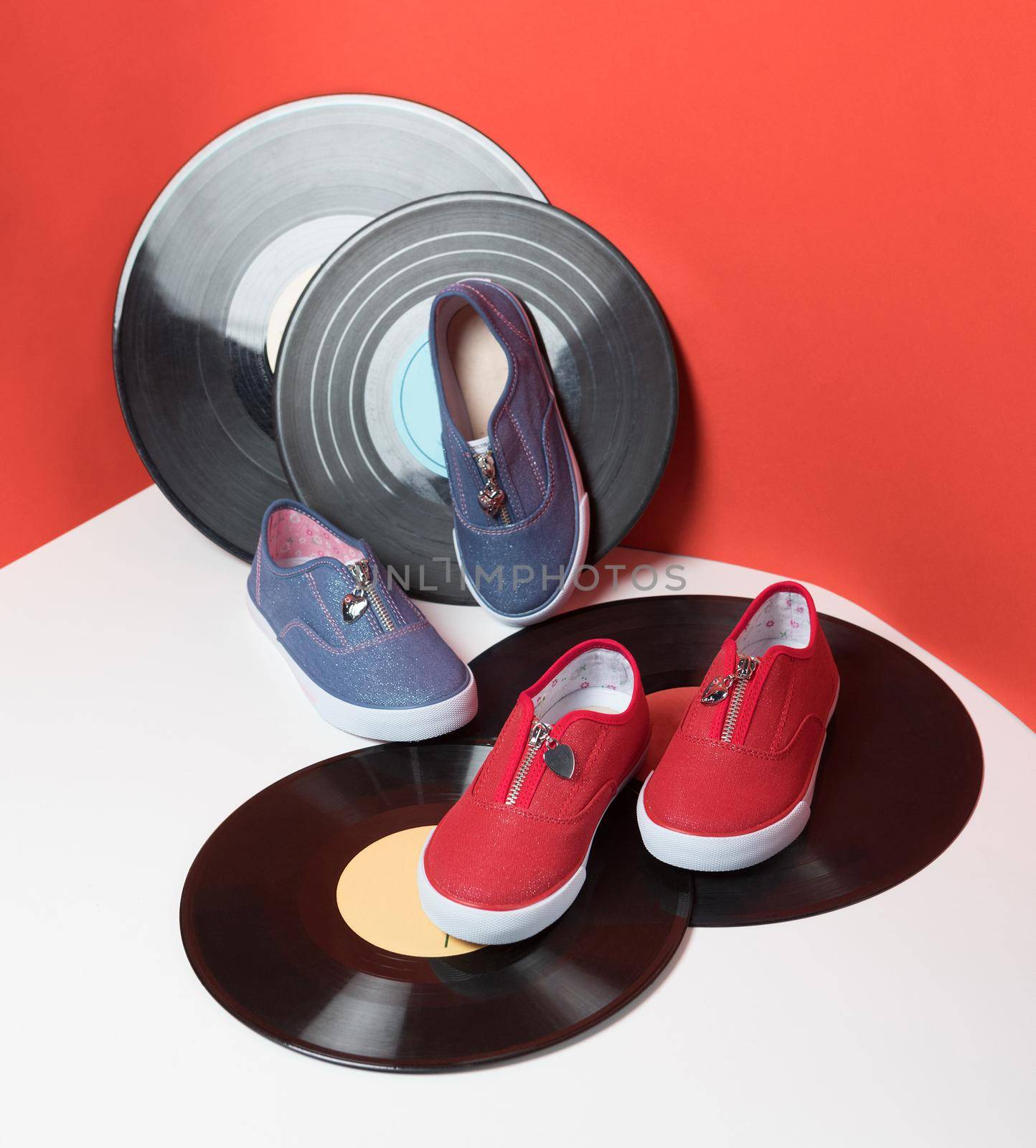 Colorful kids sport shoes isolated red background