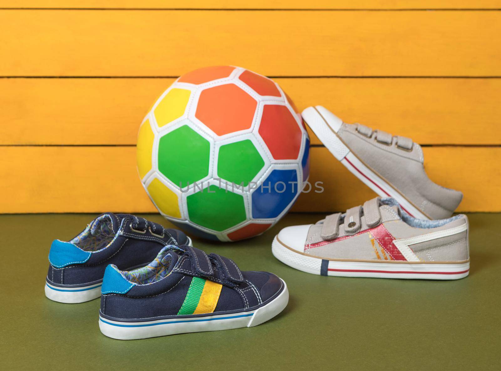 Male boy sneakers shoes with a soccer ball isolated background