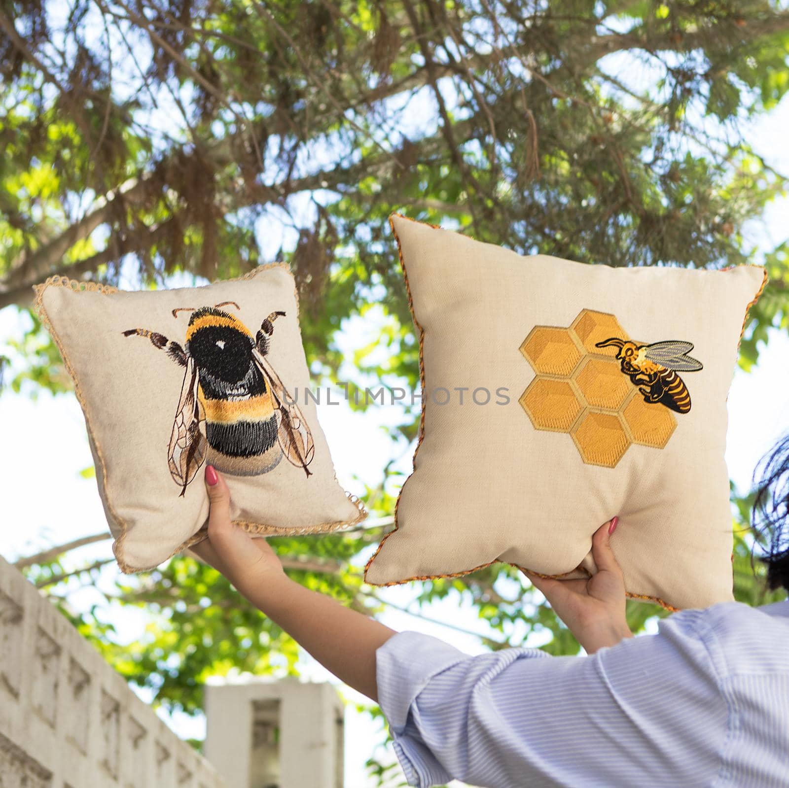 Woman holding a colorful pillow with a honey-bee photo