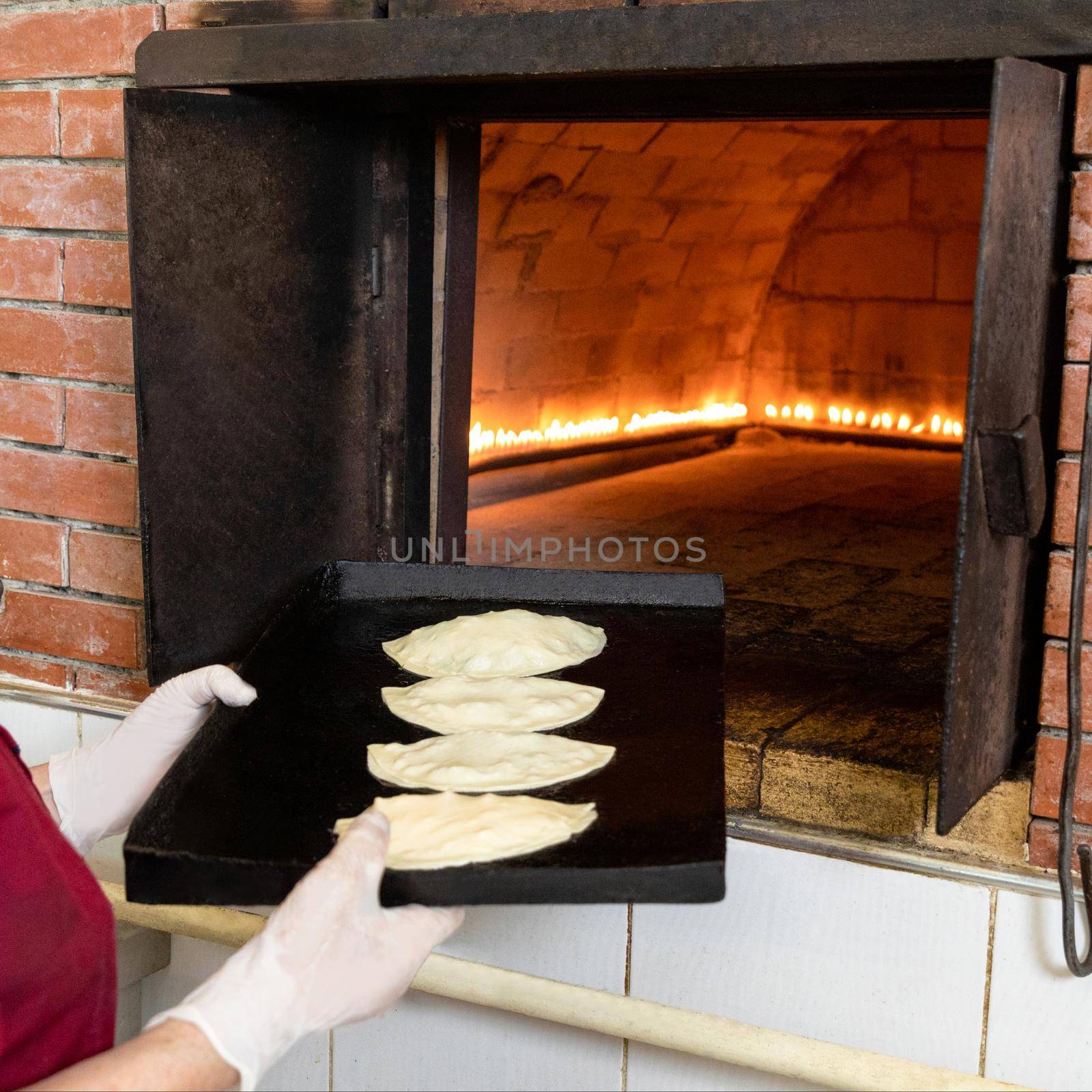 Woman putting qutab meal to the oven