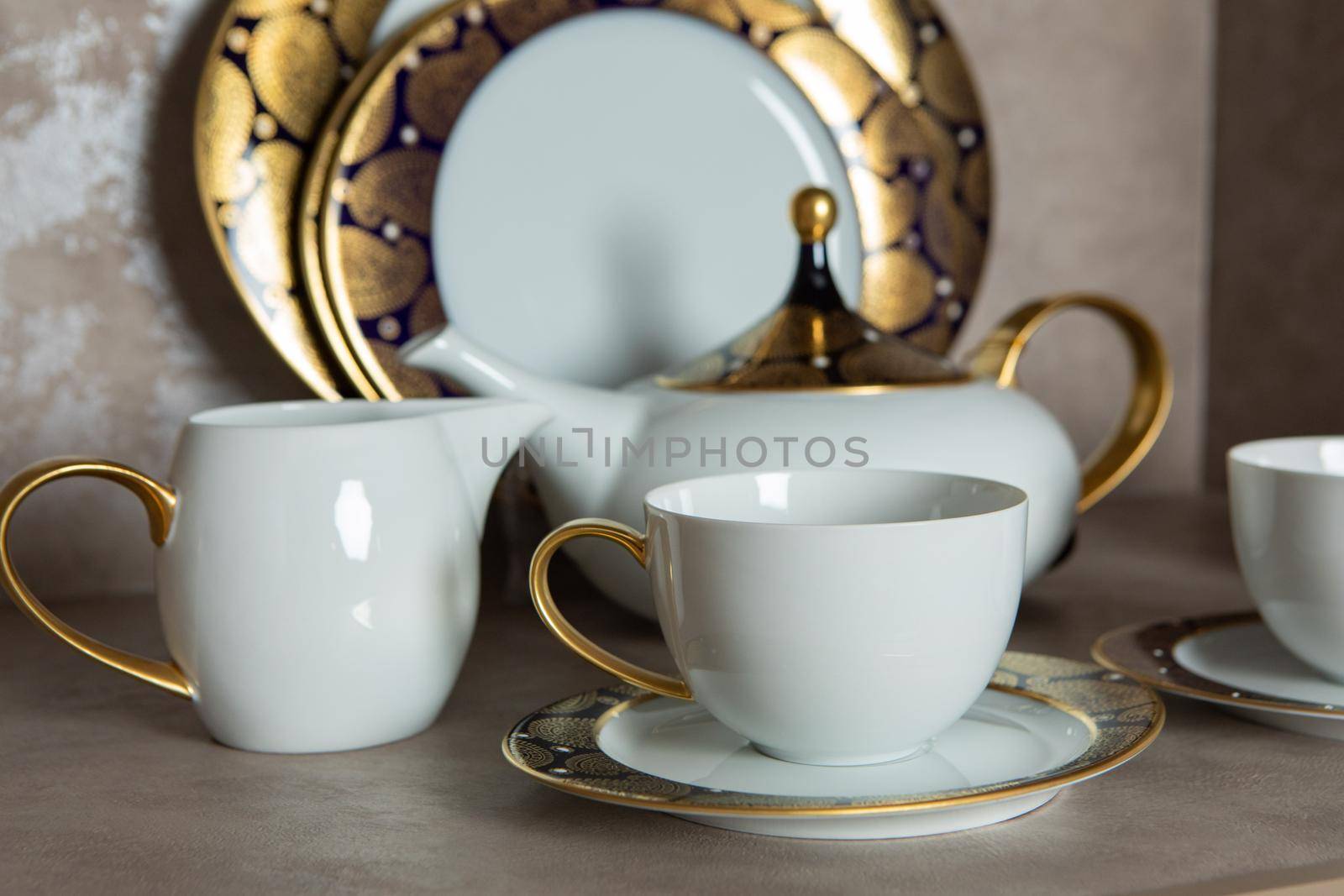 Set of clean tableware, dishes, plates, utensils, teapot on the table