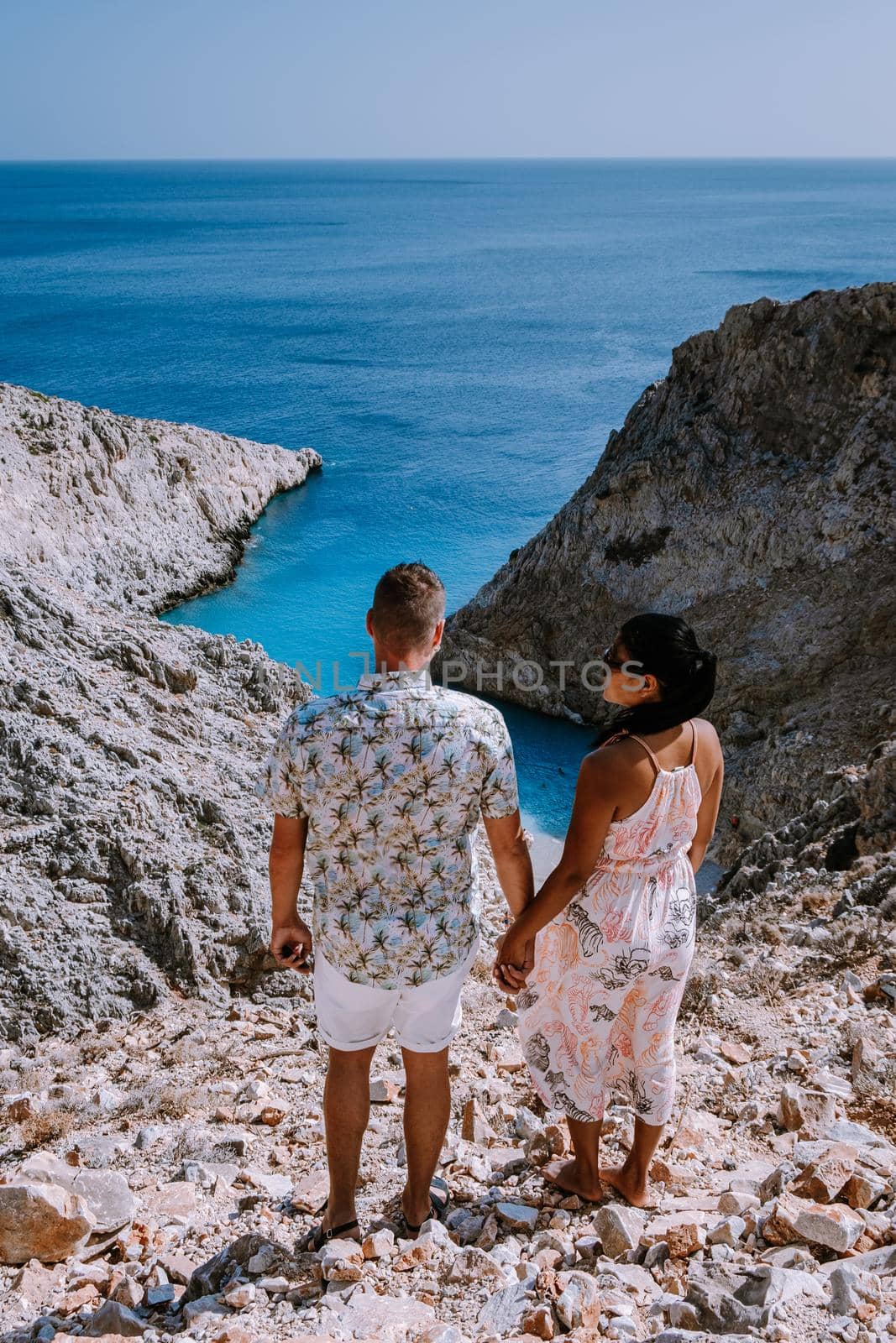 Crete Greece Seitan Limania beach with huge cliff by the blue ocean of the Island of Crete in Greece, Seitan limania beach on Crete, Greece. Europe, young couple mid age on vacation Crete 