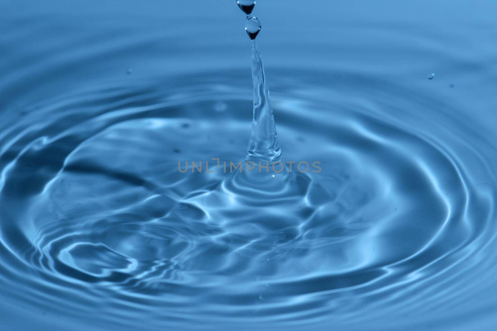 Texture, background with falling water drops and waves with blue water 