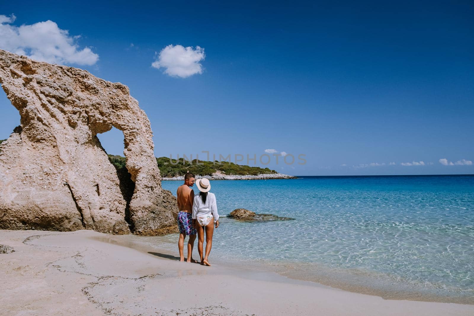 Tropical beach of Voulisma beach, Istron, Crete, Greece ,Most beautiful beaches of Crete island -Istron bay near Agios Nikolaos young couple mid age on vacation in Greece Crete