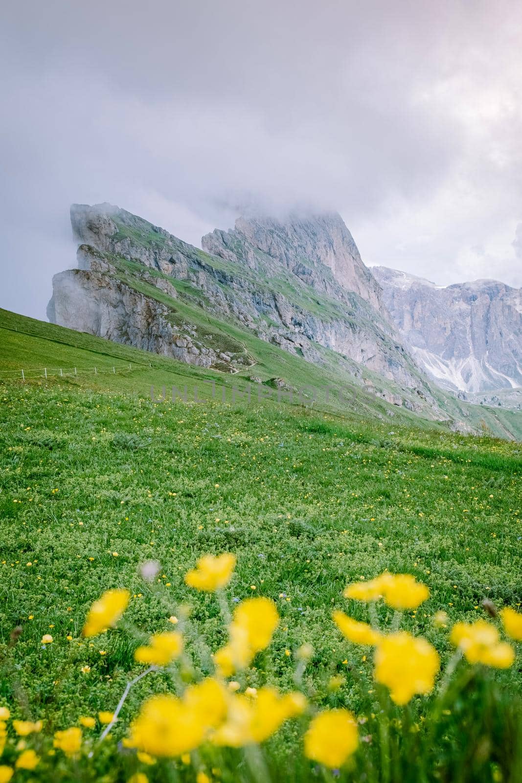 couple on vacation hiking in the Italien Dolomites, Amazing view on Seceda peak. Trentino Alto Adige, Dolomites Alps, South Tyrol, Italy, Europe. Odle mountain range, Val Gardena. Majestic Furchetta peak in morning sunlight by fokkebok