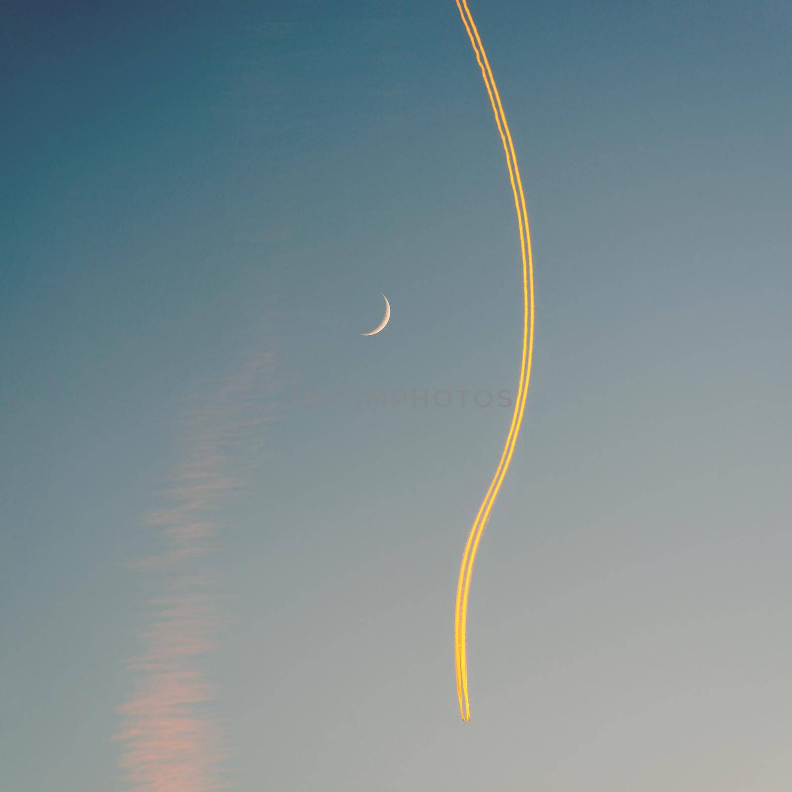 Jet airplane, its contrail and a crescent moon at sunset by dutourdumonde