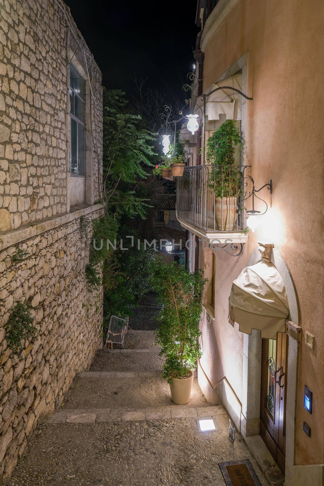 Taormina Sicily during sunset in the old town with narrow streets and lights by fokkebok