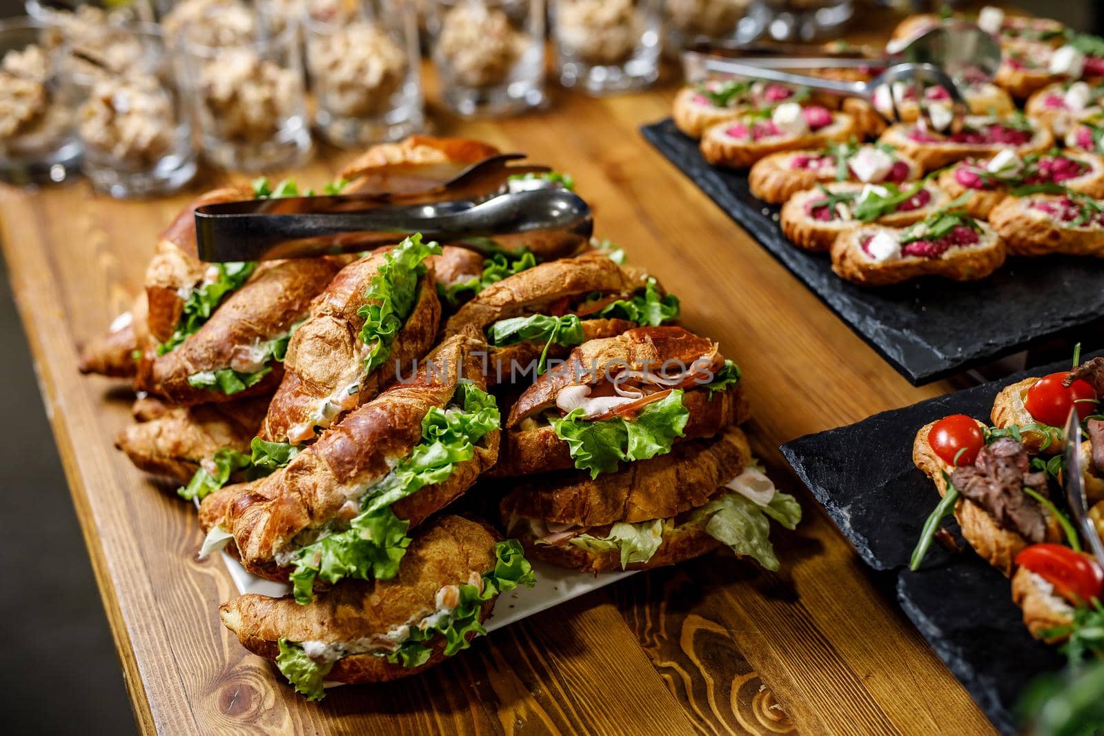 Stacks of croissant sandwich on a wooden table. by 9parusnikov