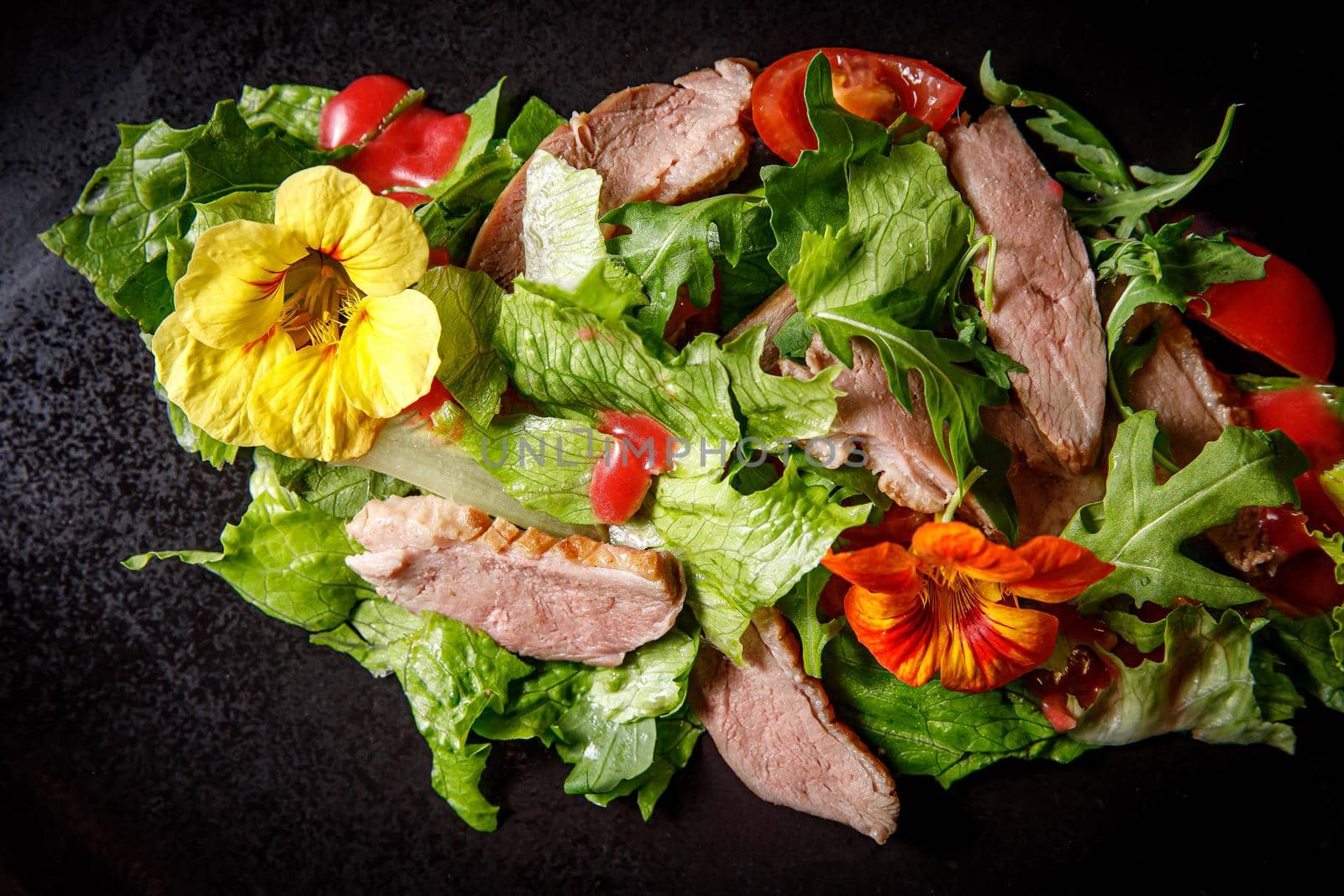 Vegetable salad with pork on a dark plate. by 9parusnikov