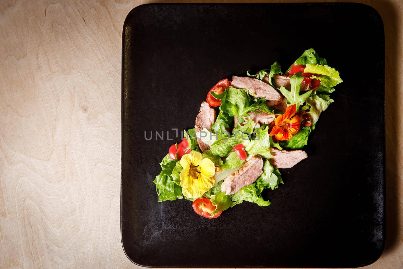 Vegetable salad with pork on a dark plate. by 9parusnikov