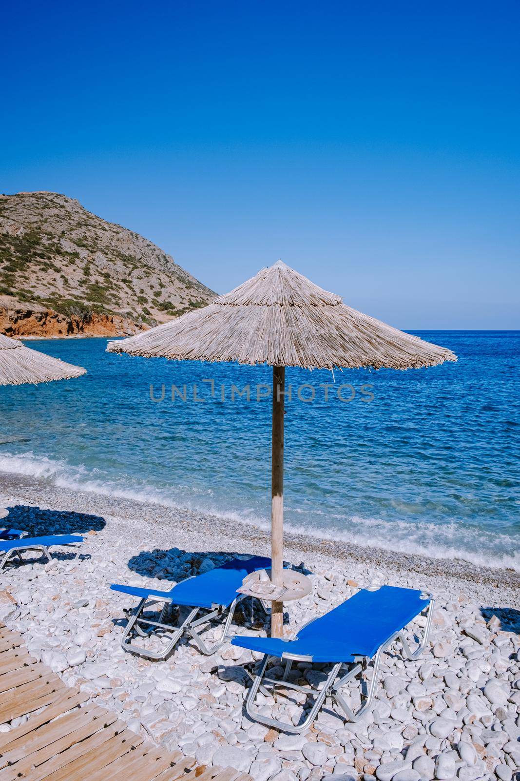 Plaka Lassithi with is traditional blue table and chairs and the beach in Crete Greece by fokkebok