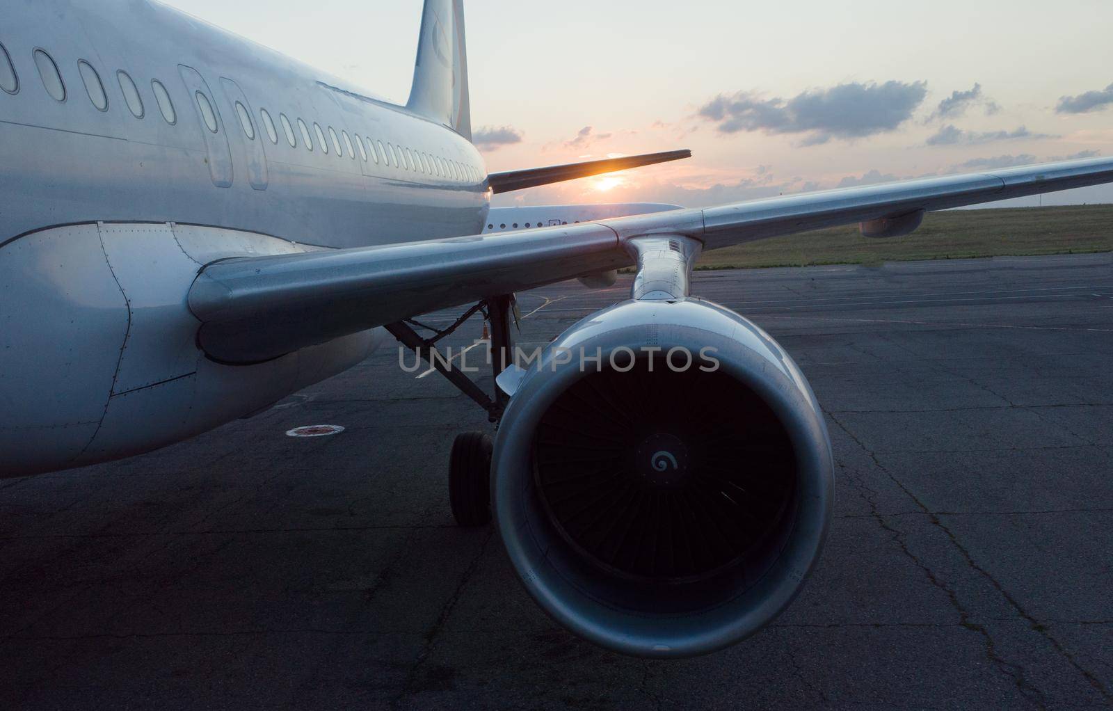The wing and engine of the plane in the light of the setting sun
