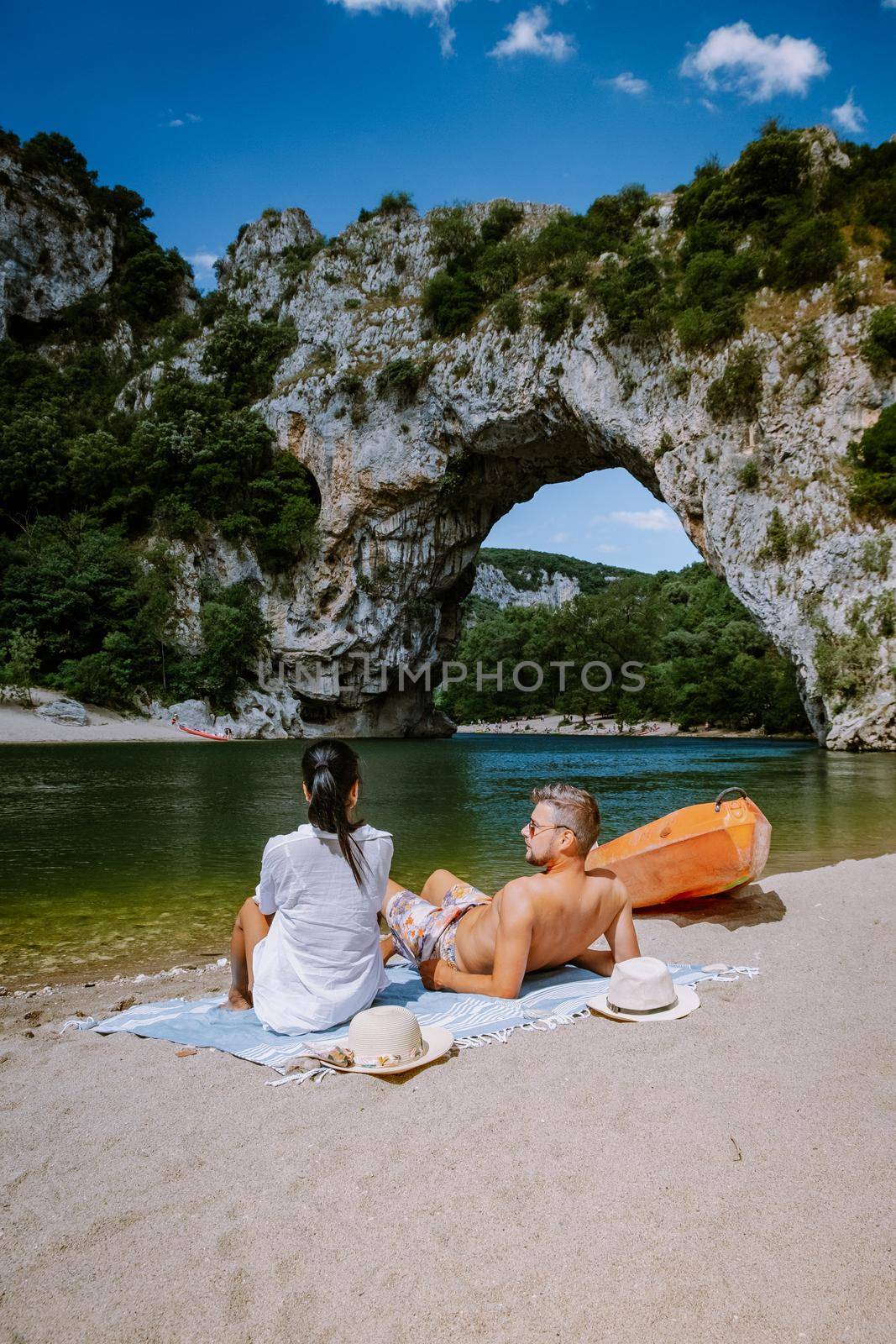 couple on the beach by the river in the Ardeche France Pont d Arc, Ardeche France,view of Narural arch in Vallon Pont D'arc in Ardeche canyon in France Europe