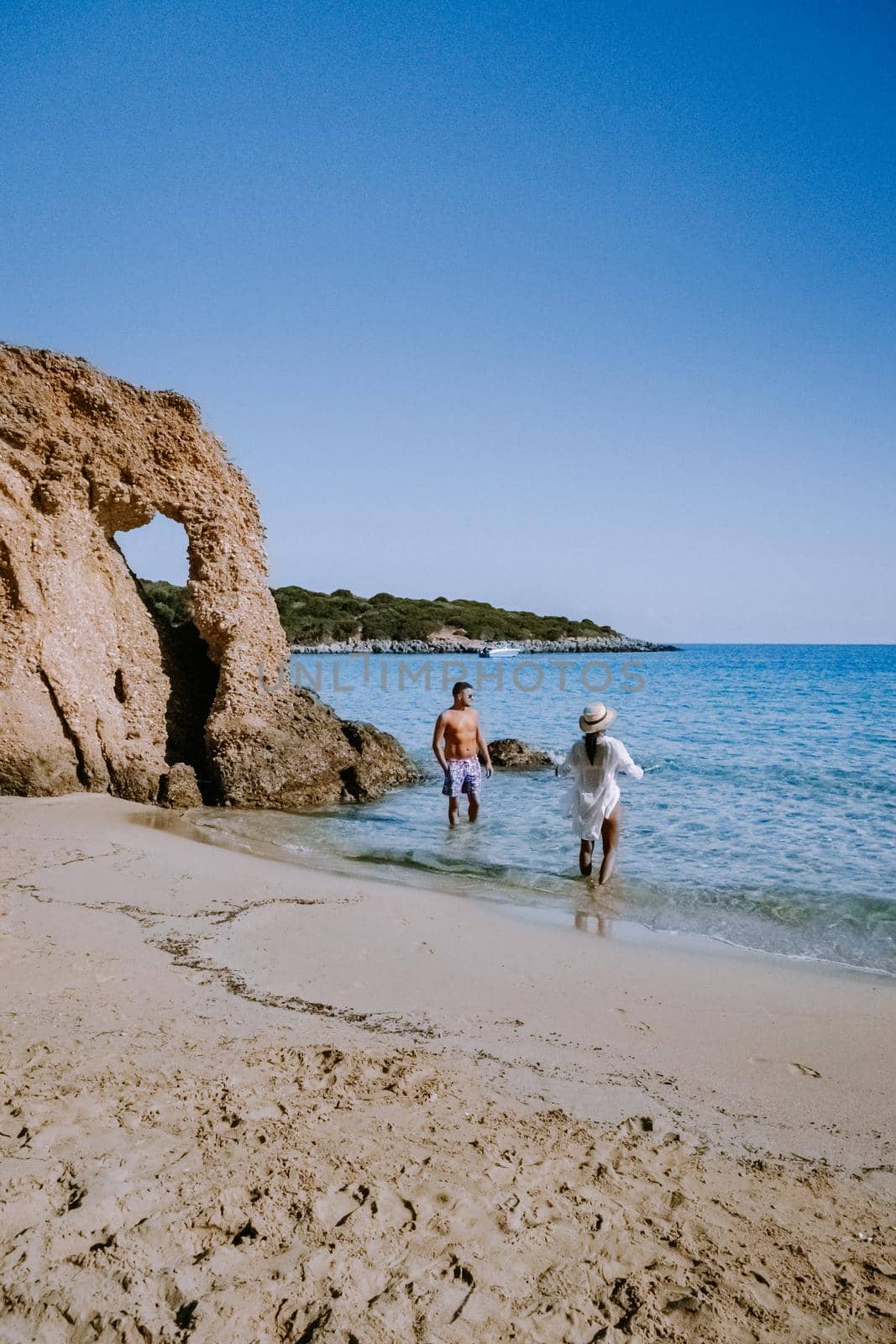 Tropical beach of Voulisma beach, Istron, Crete, Greece ,Most beautiful beaches of Crete island -Istron bay near Agios Nikolaos young couple mid age on vacation in Greece Crete