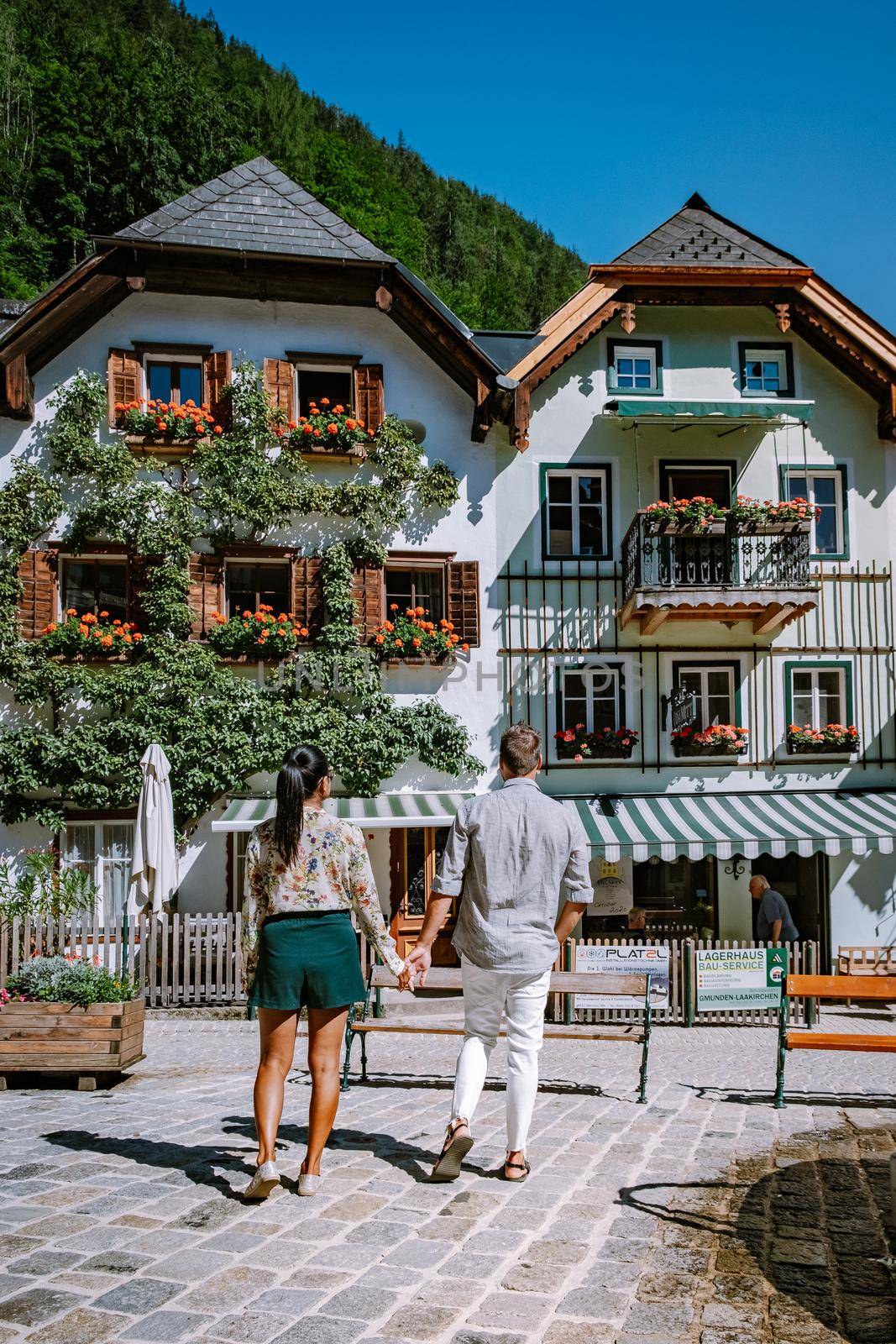 couple visit Hallstatt village on Hallstatter lake in Austrian Alps Austria by fokkebok