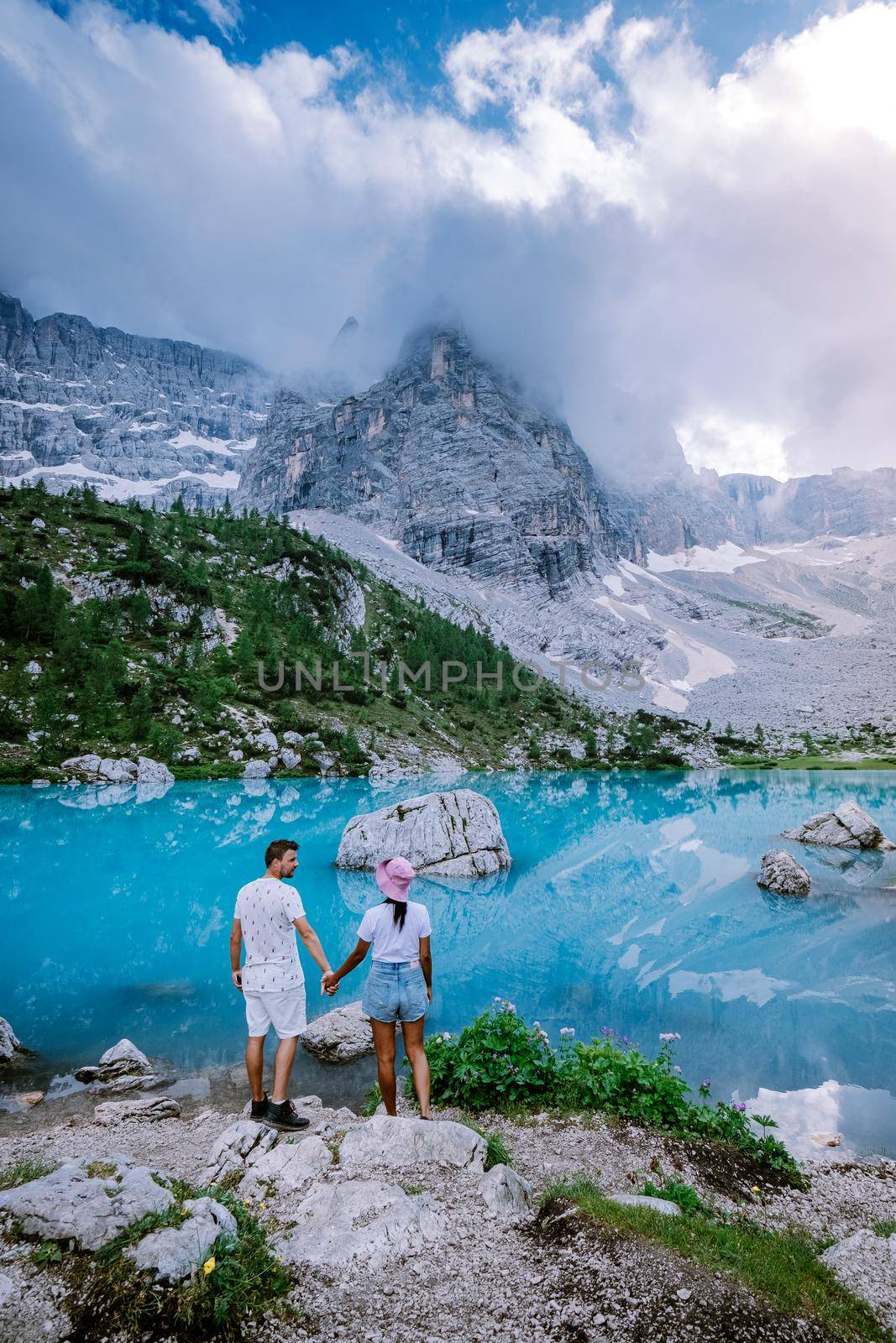 Couple visit the blue green lake in the Italian Dolomites,Beautiful Lake Sorapis Lago di Sorapis in Dolomites, popular travel destination in Italy. Europe