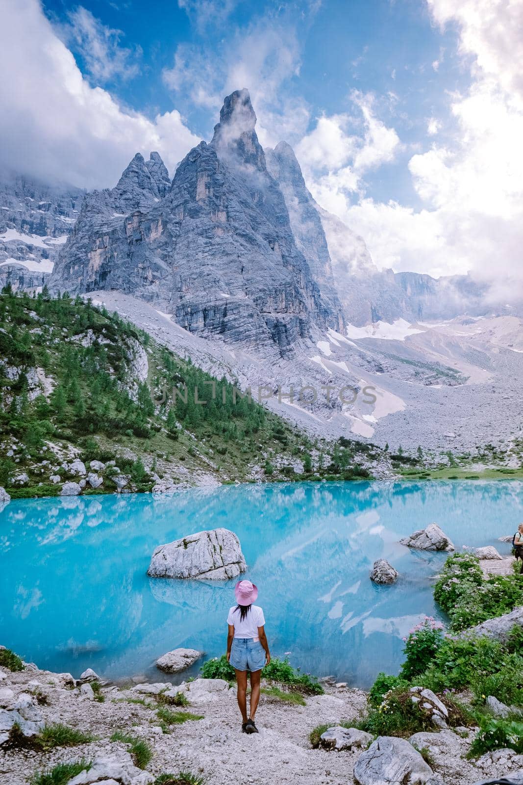 woman hiking to blue green lake in the Italian Dolomites,Beautiful Lake Sorapis Lago di Sorapis in Dolomites, popular travel destination in Italy. Europe