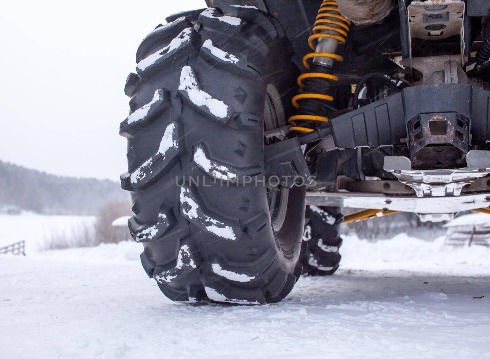 Close-up of a quad bike wheel and 4-wheel drive. ATV in the forest in winter. Riding a quad bike.