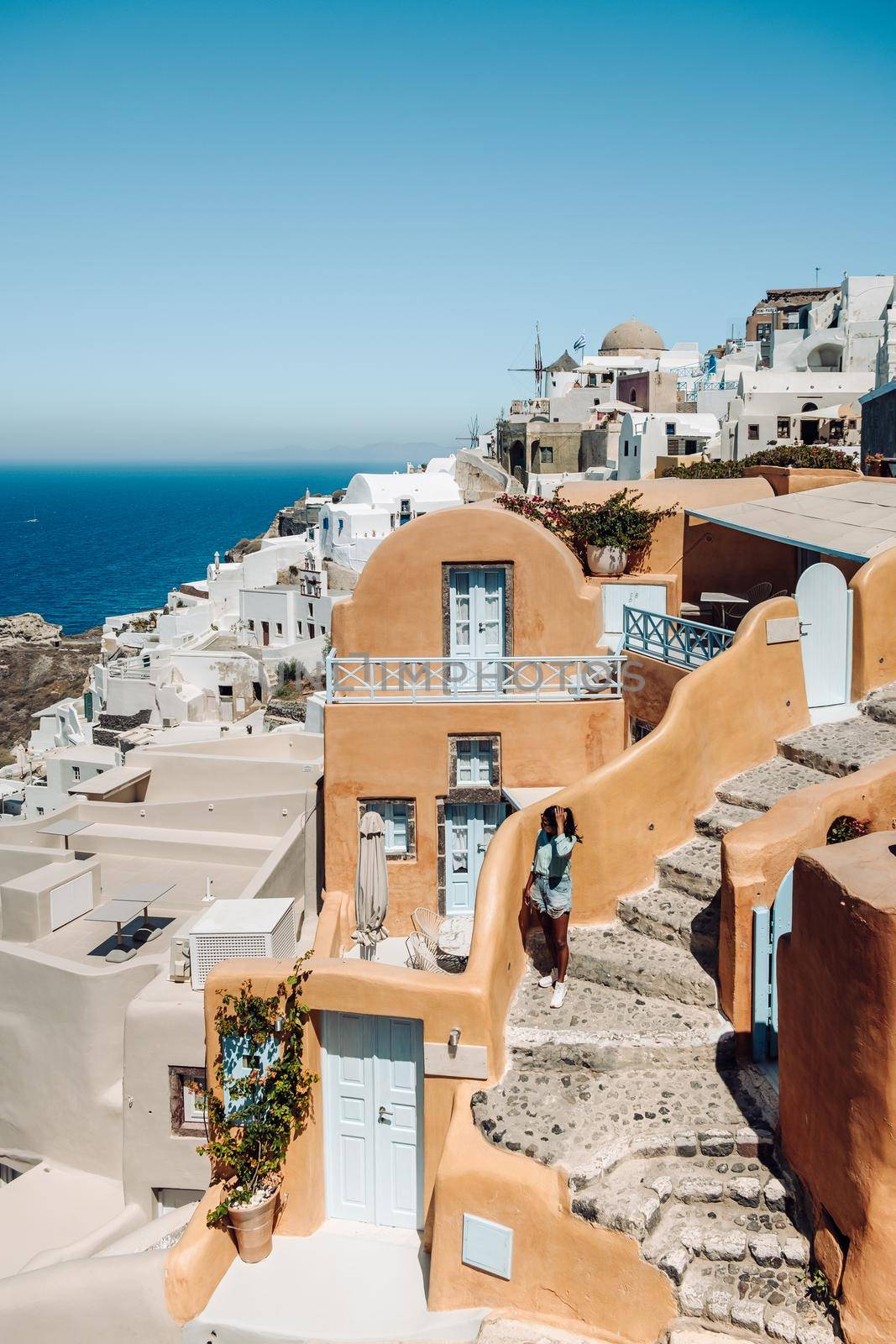 Santorini Greece, young man on luxury vacation at the Island of Santorini watching sunrise by the blue dome church and whitewashed village of Oia Santorini Greece during sunrise during summer vacation, men on holiday in Greece