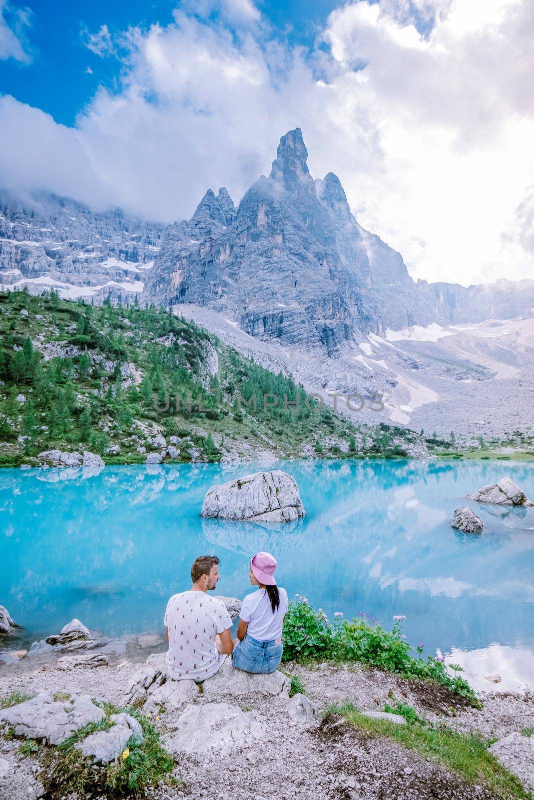 Couple visit the blue green lake in the Italian Dolomites,Beautiful Lake Sorapis Lago di Sorapis in Dolomites, popular travel destination in Italy. Europe