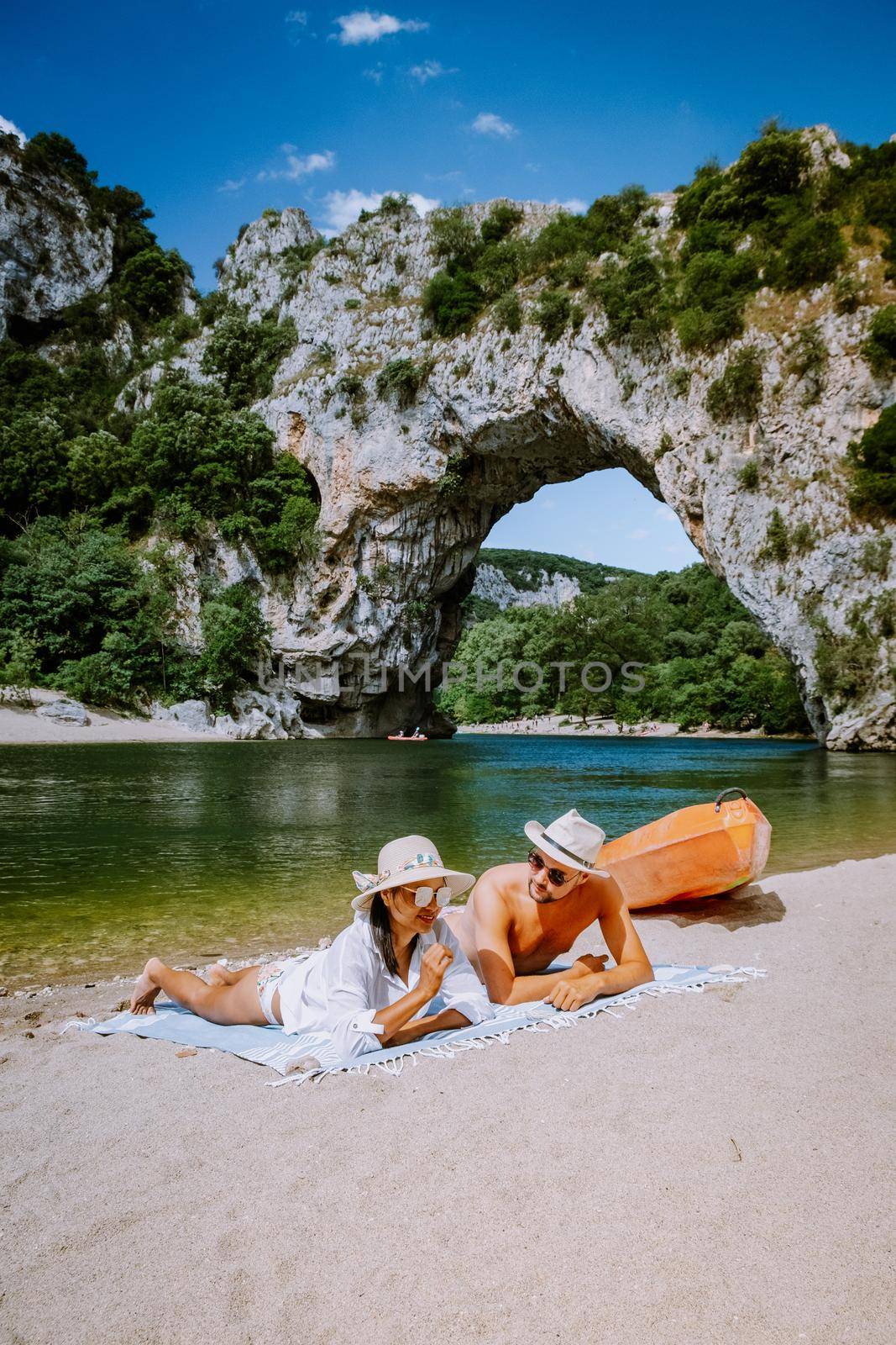 couple on the beach by the river in the Ardeche France Pont d Arc, Ardeche France,view of Narural arch in Vallon Pont D'arc in Ardeche canyon in France Europe