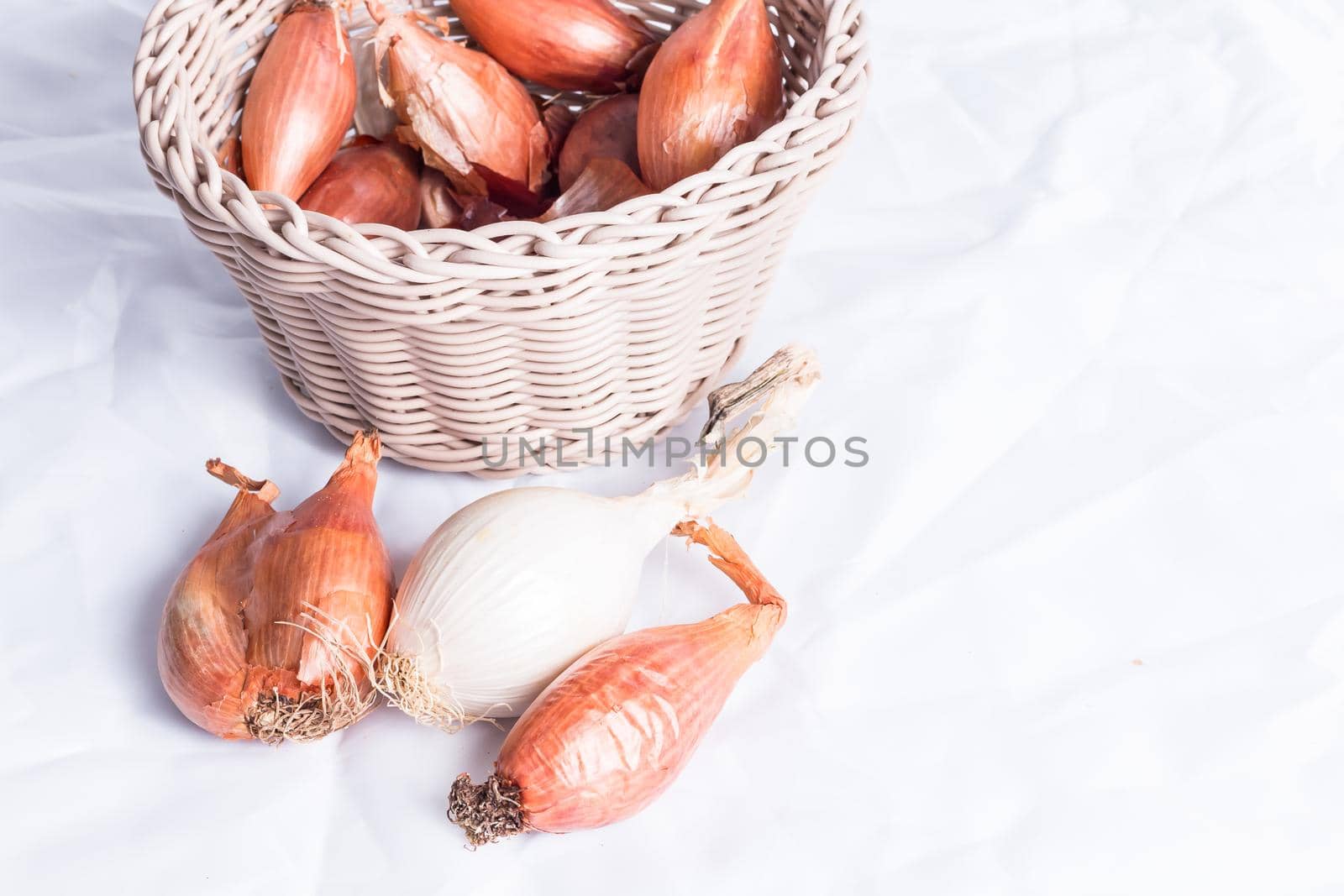 shallot in a wicker basket on a white background