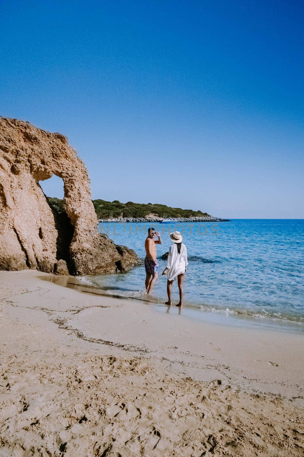 Tropical beach of Voulisma beach, Istron, Crete, Greece ,Most beautiful beaches of Crete island -Istron bay near Agios Nikolaos young couple mid age on vacation in Greece Crete