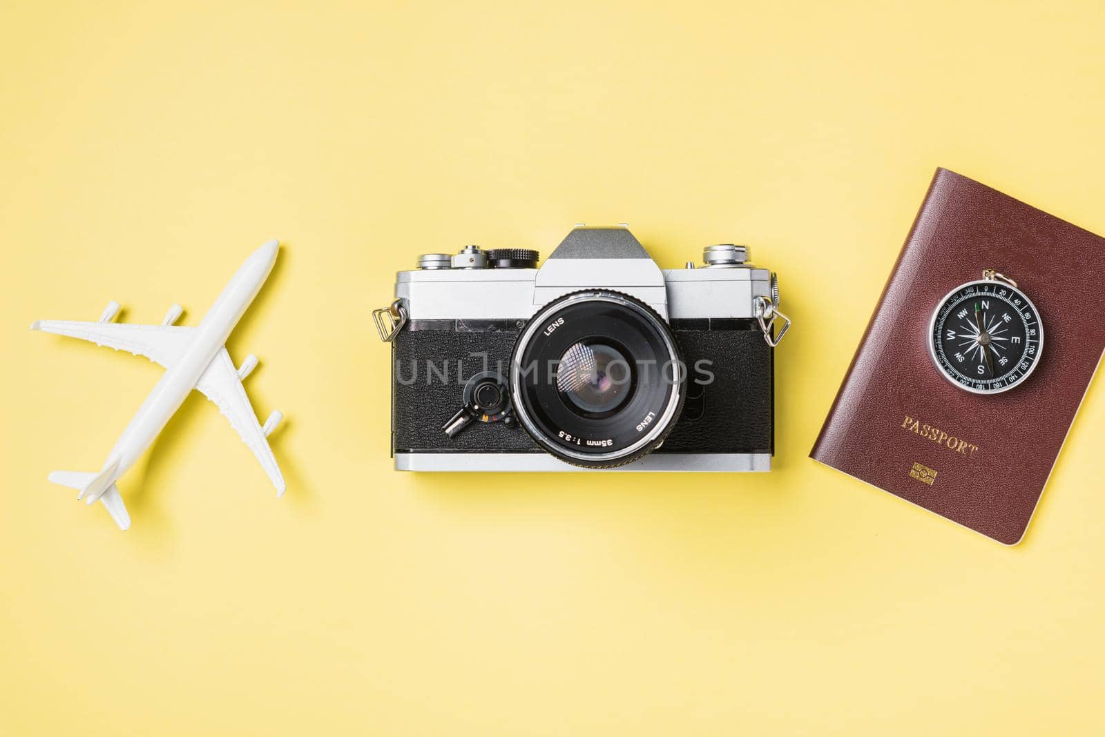 Flat lay top view mockup retro camera films, airplane, traveler tropical accessories on a yellow background with copy space, Vacation summer travel and business trip concept