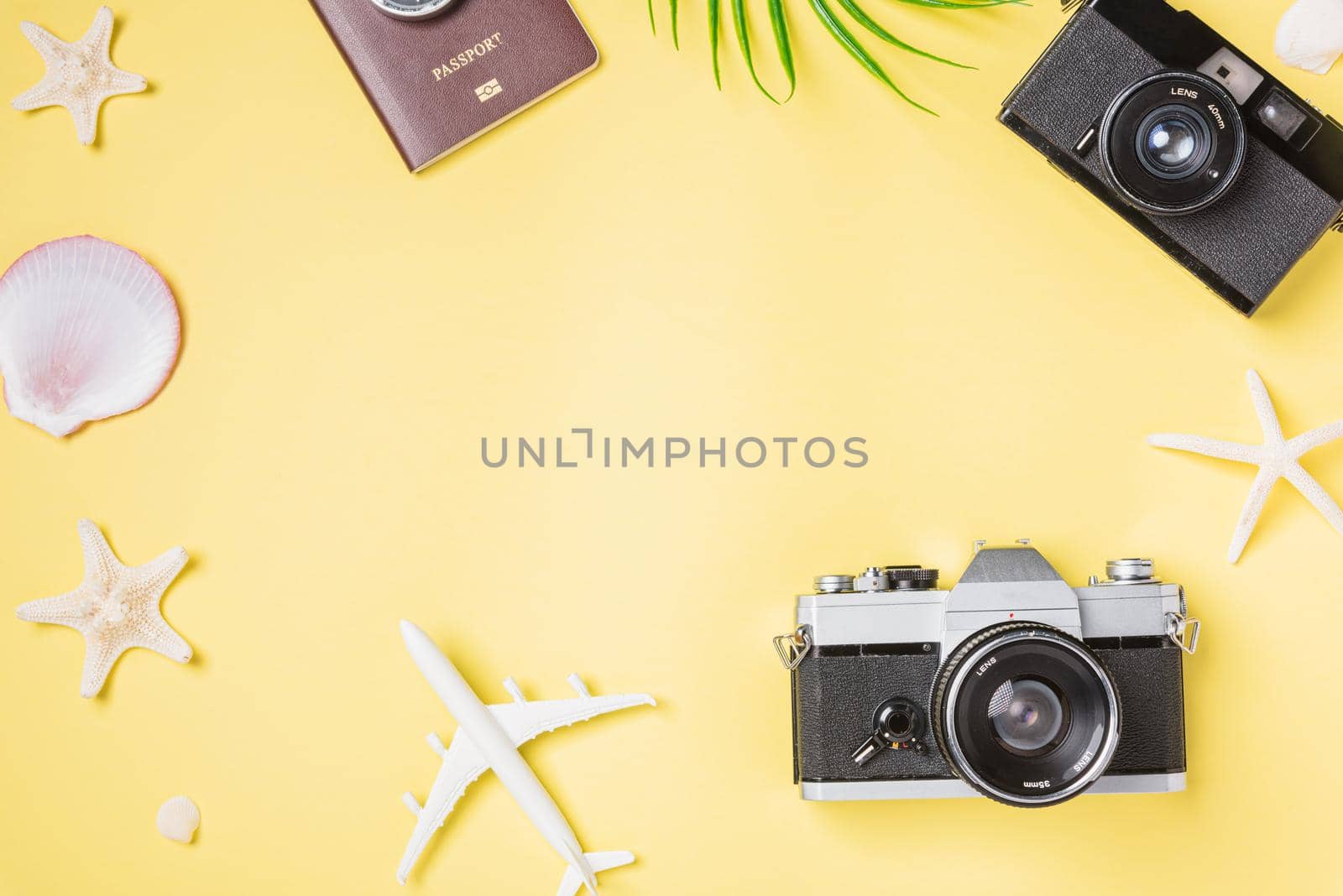 Flat lay top view mockup retro camera films, airplane, leaves, starfish traveler tropical beach accessories on a yellow background with copy space, Vacation summer travel and business trip concept