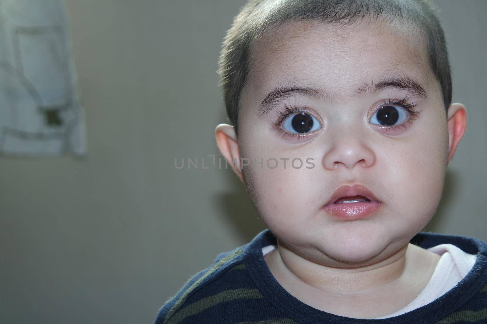 Baby girl with lovely face, big eyes and cute face gesture. Toddler baby making sweet activities