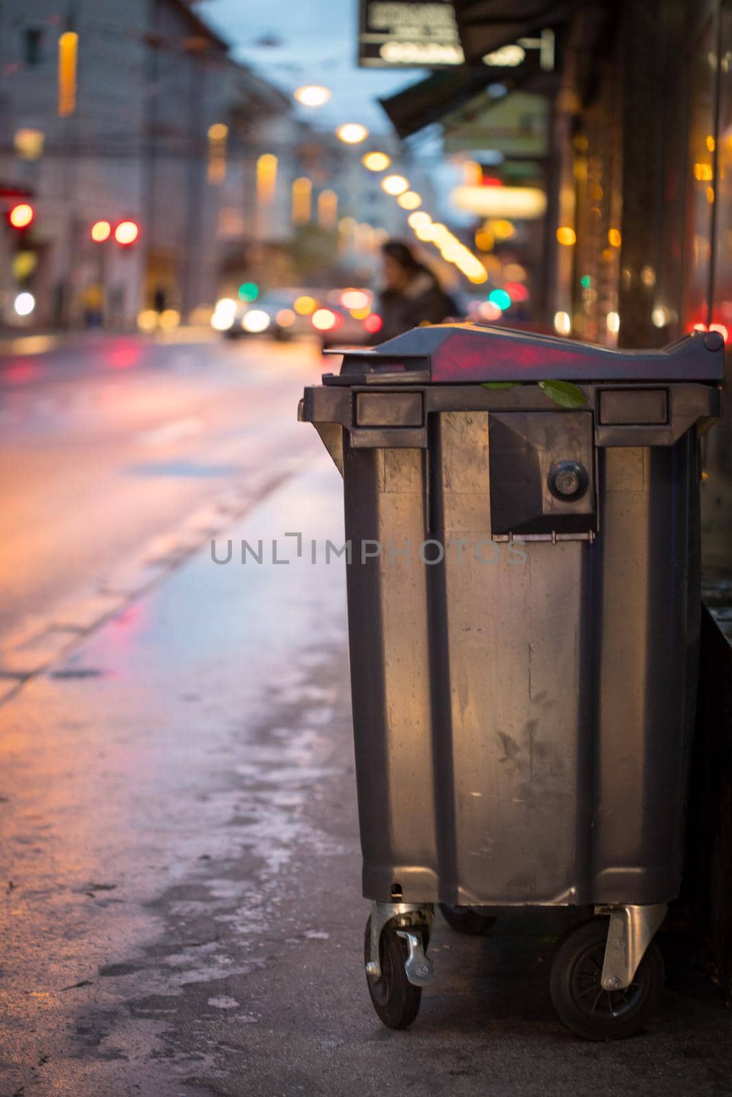 Garbage cans and street lights in urban city, evening by Daxenbichler