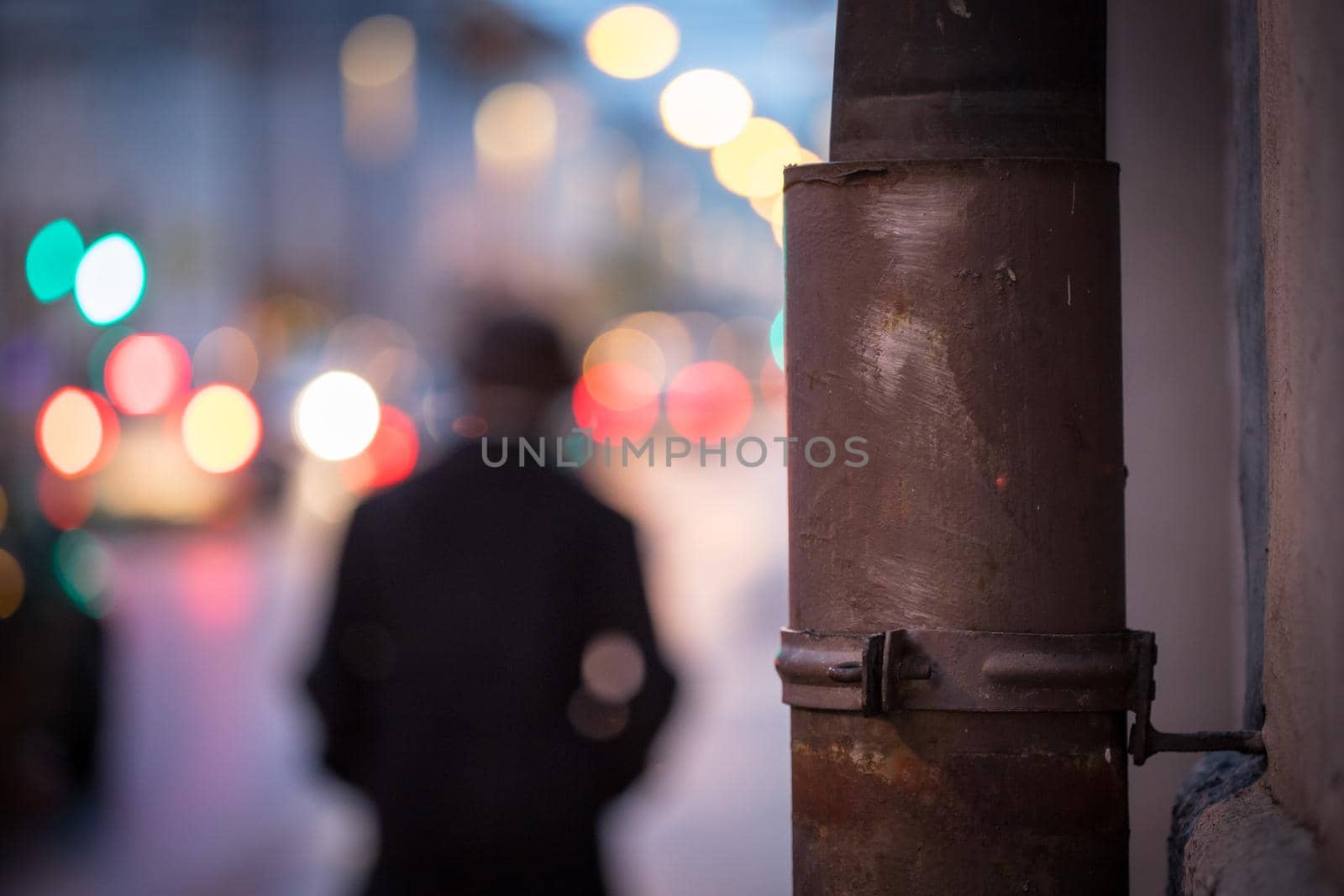 Closeup of rain drain, urban city lights in the blurry background
