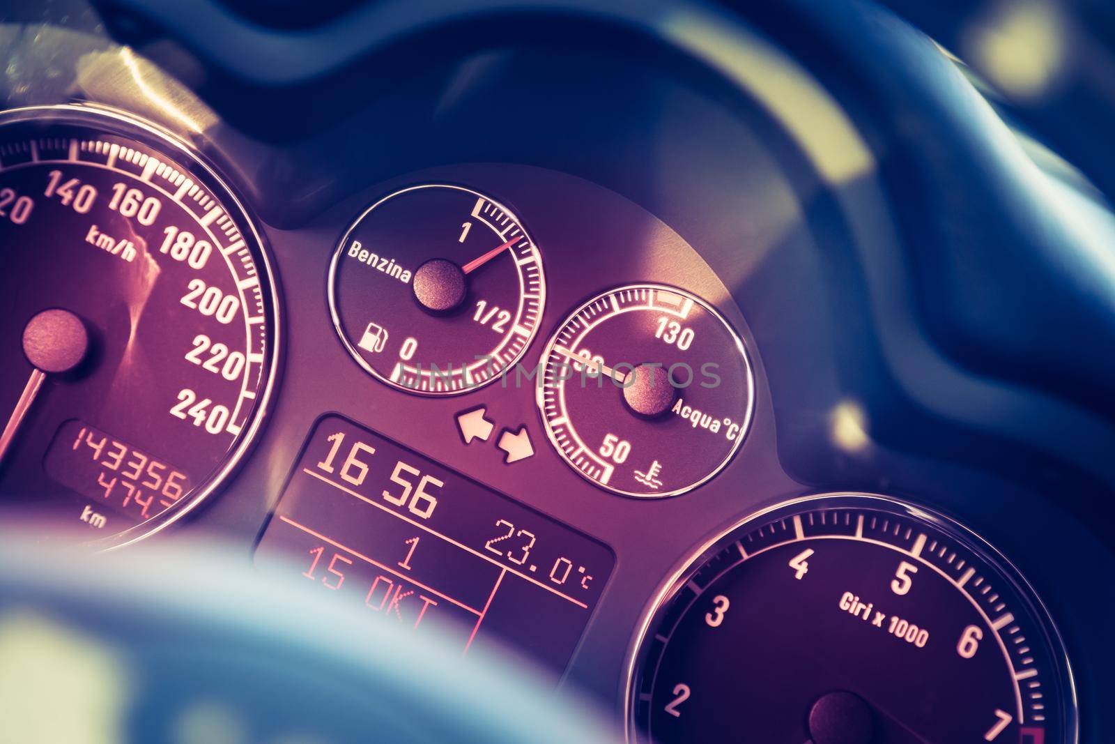 Closeup of the dashboard of a sports car, tachometer and fuel indicator